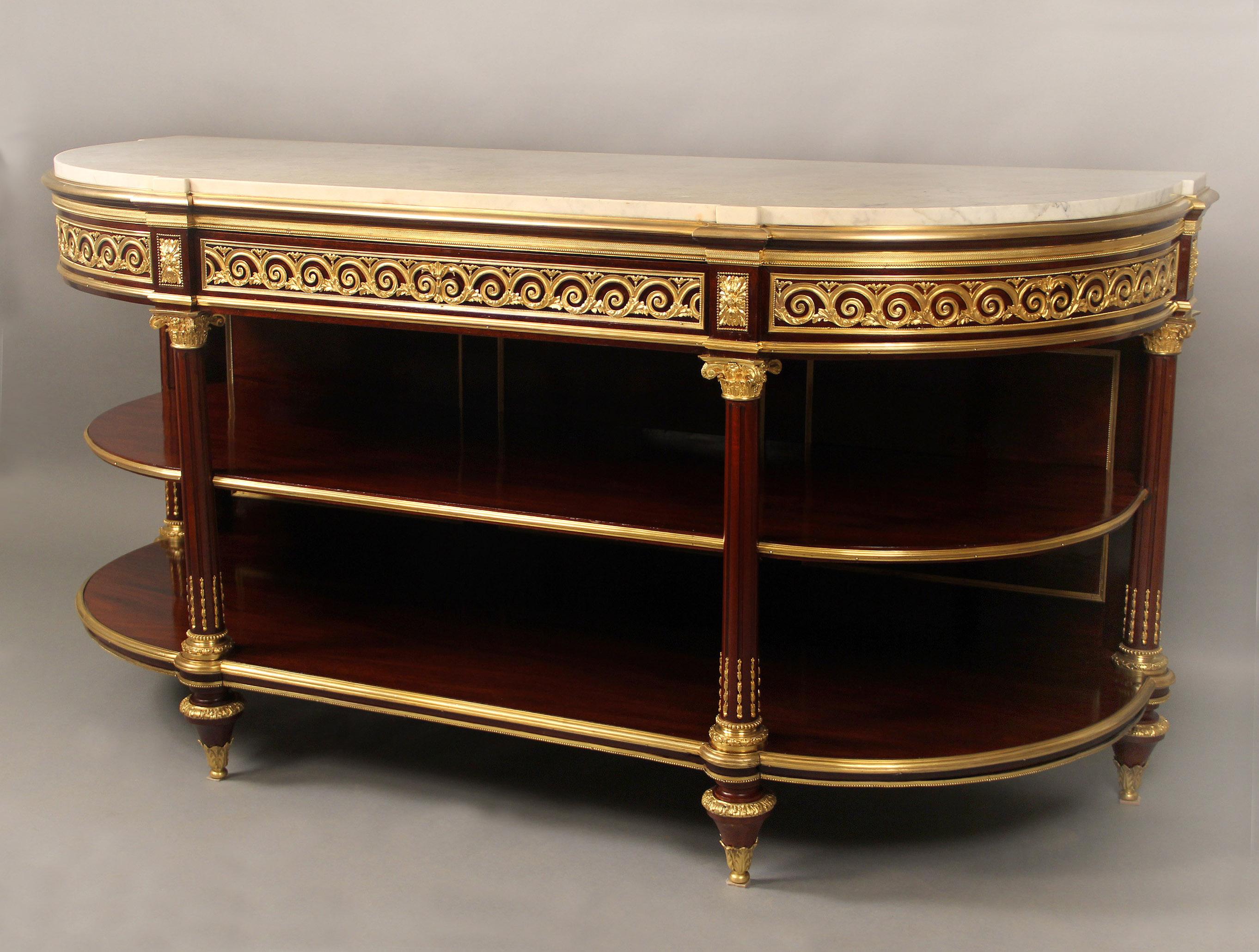 Fine late 19th century gilt bronze mounted Louis XVI style mahogany three-tier dessert console / server.

A white demilune marble top above a single long drawer, fitted with compartments, and two open storage shelves, two front and two side columns