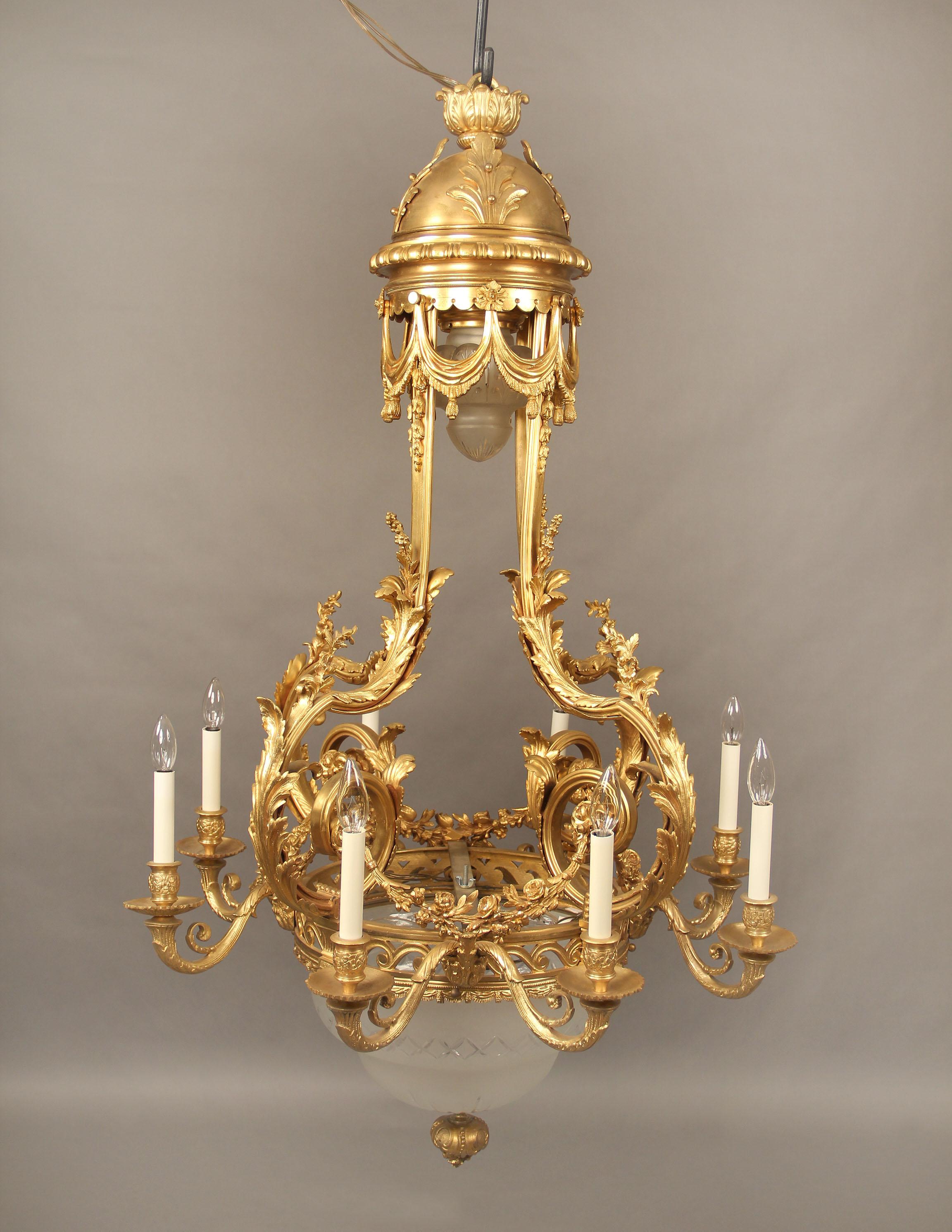 A fine late 19th century gilt bronze thirteen-light chandelier.

A gilt bronze floral and foliate frame with casted scrolled arms, the top shaped as a dome with flowing curtains and a lit shade, the bottom centered with an etched crystal bowl.