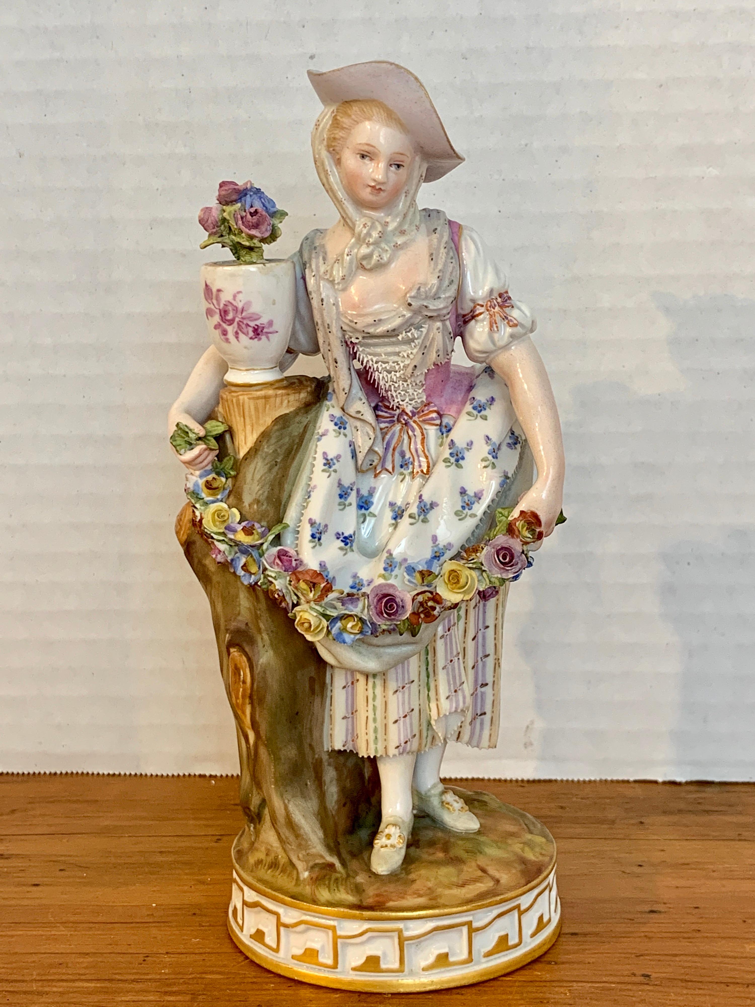 Fine late 19th century Meissen figurine of a Lady Gardener, of typical form with the period dress maiden holding a garland of flowers. Good Antique condition, some minor losses on the flowers and leaves, all expected wear.

 