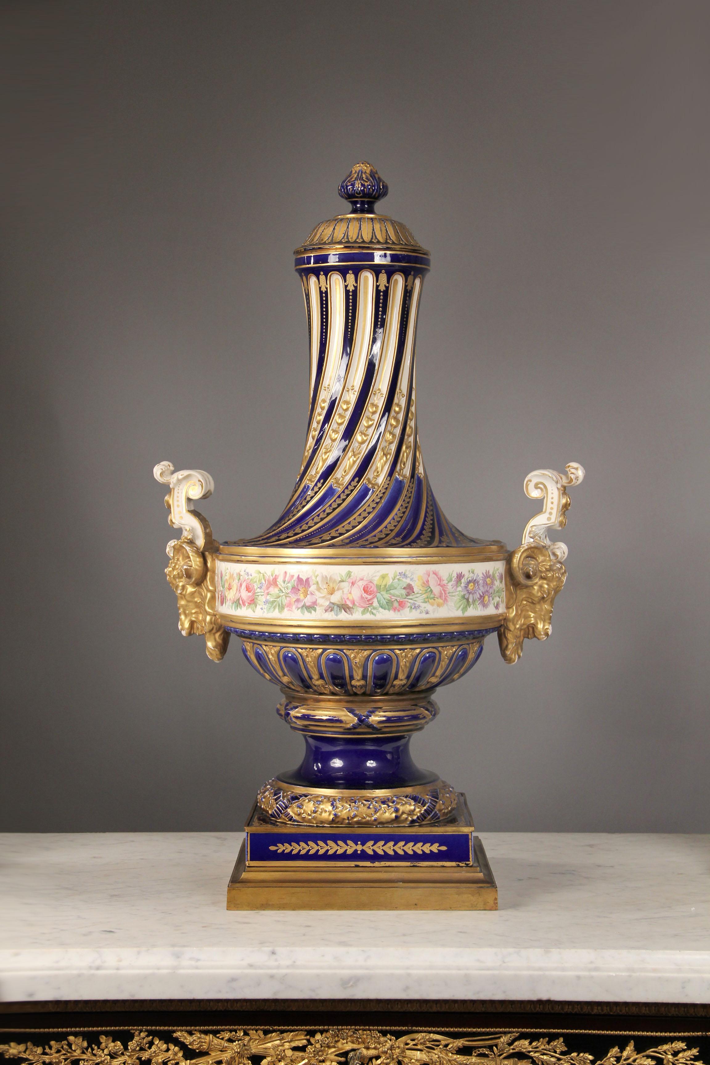 Feine Porzellanvase aus vergoldeter Bronze und Sèvres im späten 19.


Über einem langen, verzierten Spiralhals mit erhabenen, vergoldeten Motiven, umgeben von einem floralen Fries und flankiert von großen Widderköpfen, steht ein vergoldeter