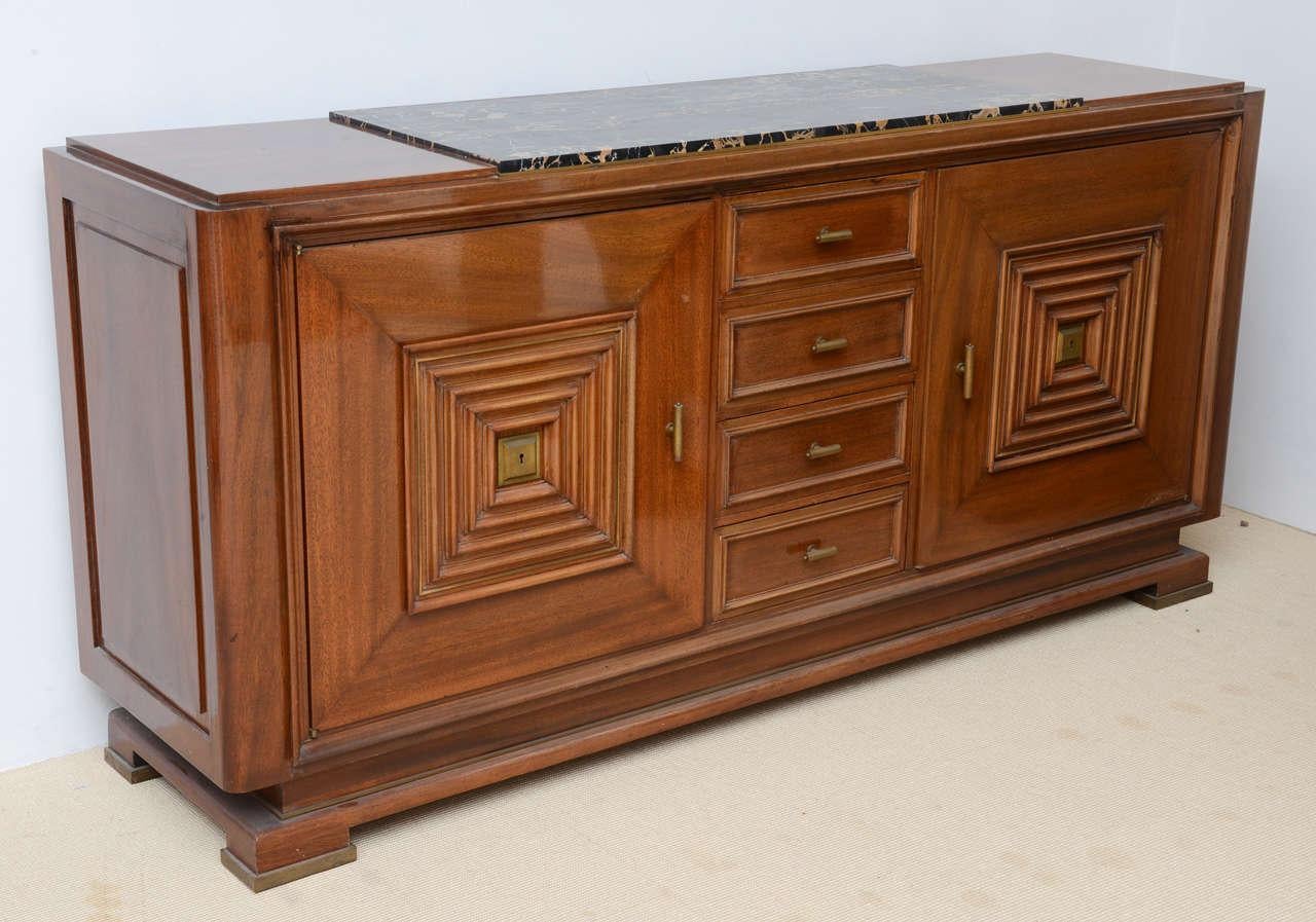 The top with inset marble above four central drawers flanked by cabinet doors, the style of Maxime Old.