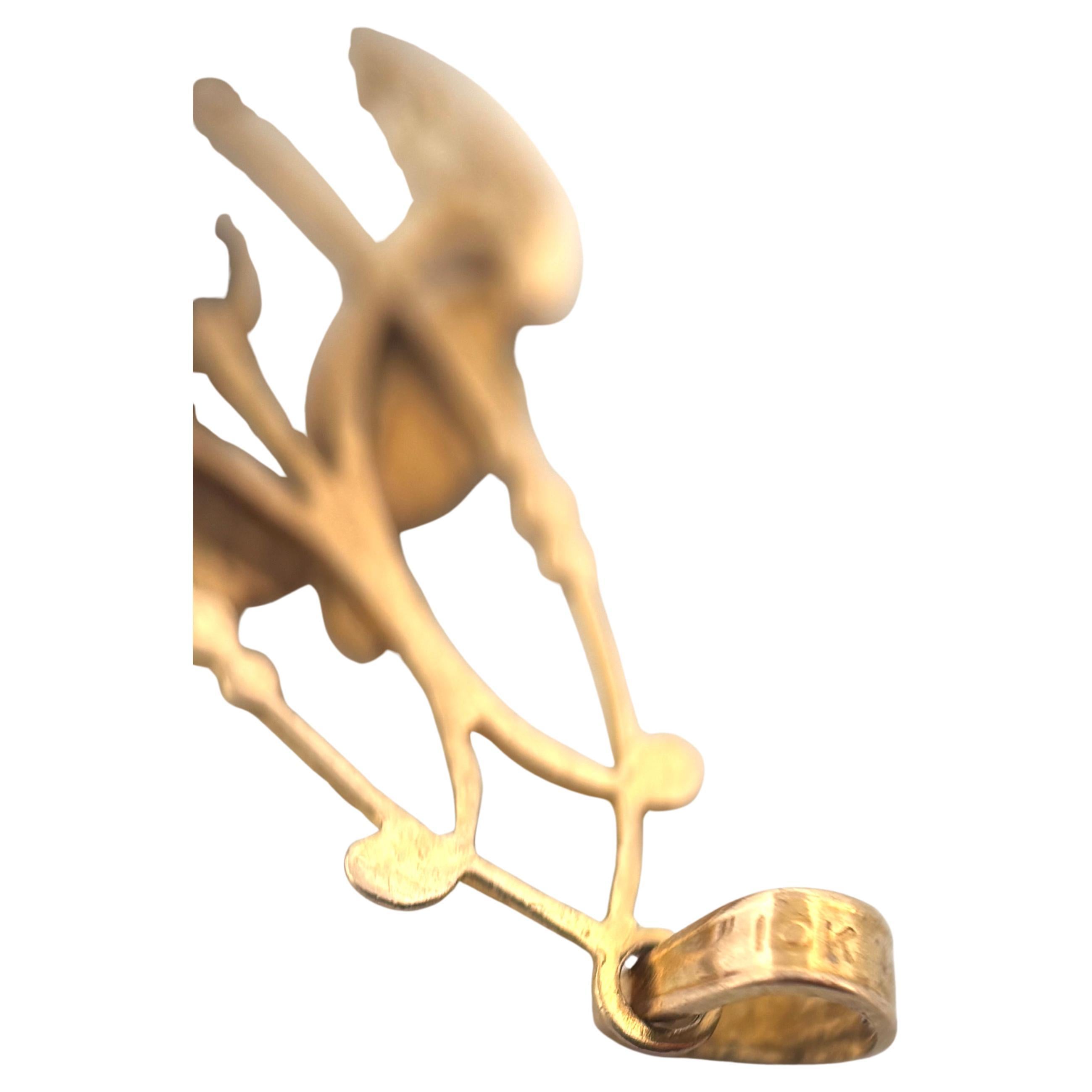 Questo raffinato ciondolo a forma di lavalier di ispirazione edoardiana è realizzato in oro giallo 10K, pesa 1,0 grammi e misura circa 1,25 pollici di lunghezza. Il grazioso design traforato presenta delicati motivi a volute e accenti fogliati, che