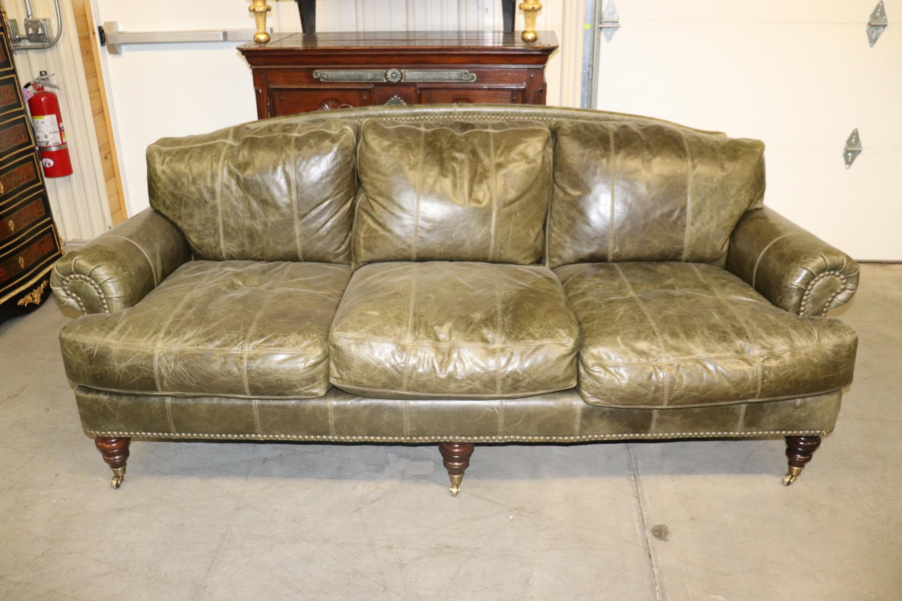 This is a gorgeous distressed leather in green Lillian August sofa in the Edwardian taste with wheels and brass toes. The sofa measures 84 long x 36 deep x 35 tall and the seat height is 21 inches tall. The sofa has an 