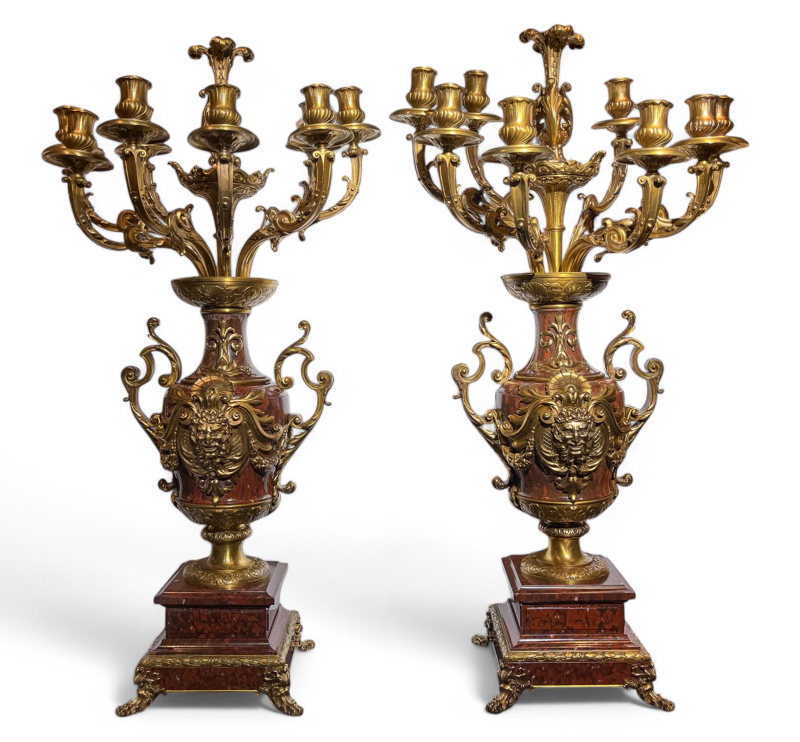 Composto da un centrotavola jardiniere e da una coppia di candelabri a nove bracci in marmo rosso. La giardineria presenta montature in bronzo dorato con elaborate forme di volute e una grande conchiglia al centro del corpo. I candelabri a forma di