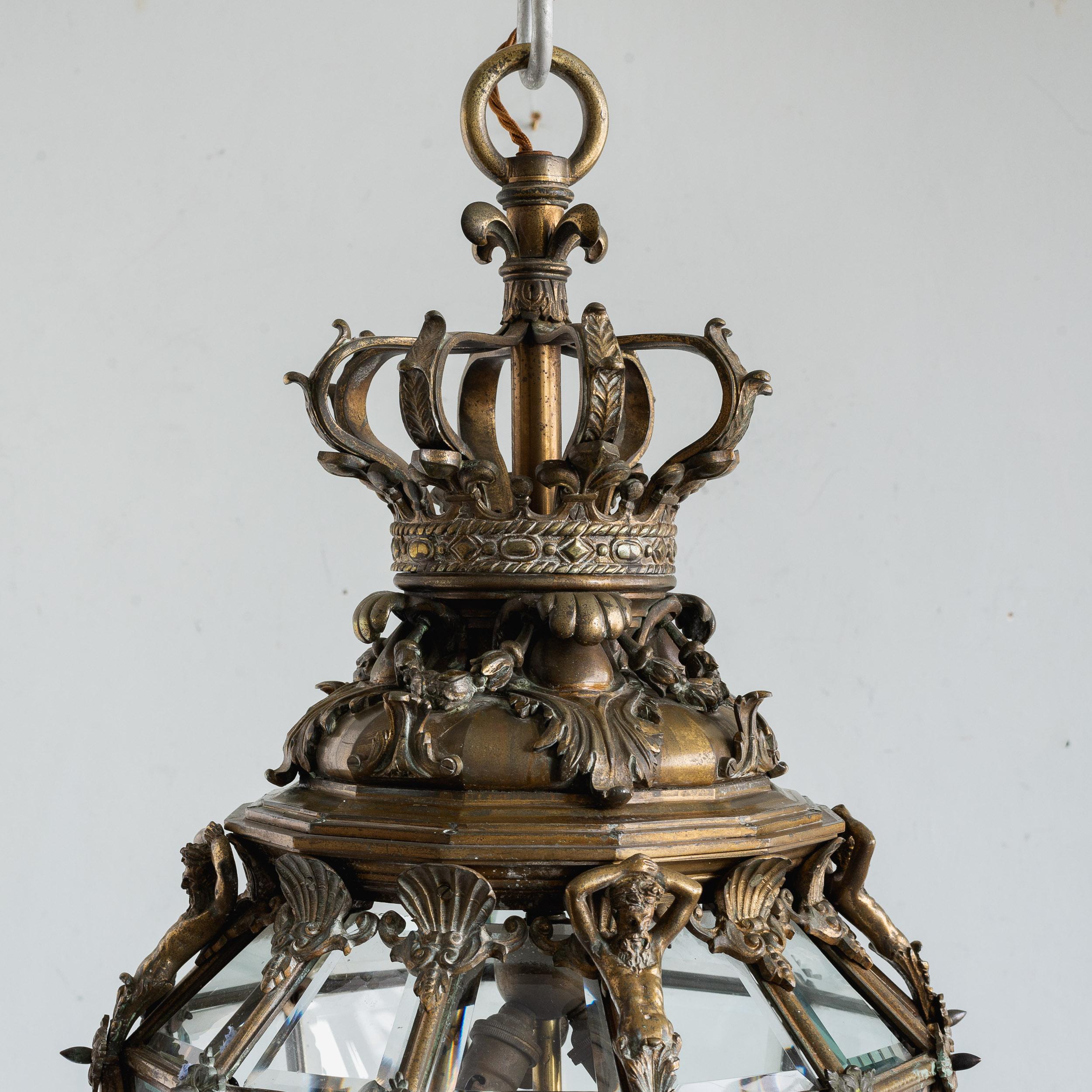 A fine quality Louis XIV style gilt-bronze lantern, late 19th or early 20th century, after a design originally made for the 'Vestibule de Marbre' at the Palace of Versaille, the top formed of a Royal Crown, the bevelled glass panelled body with