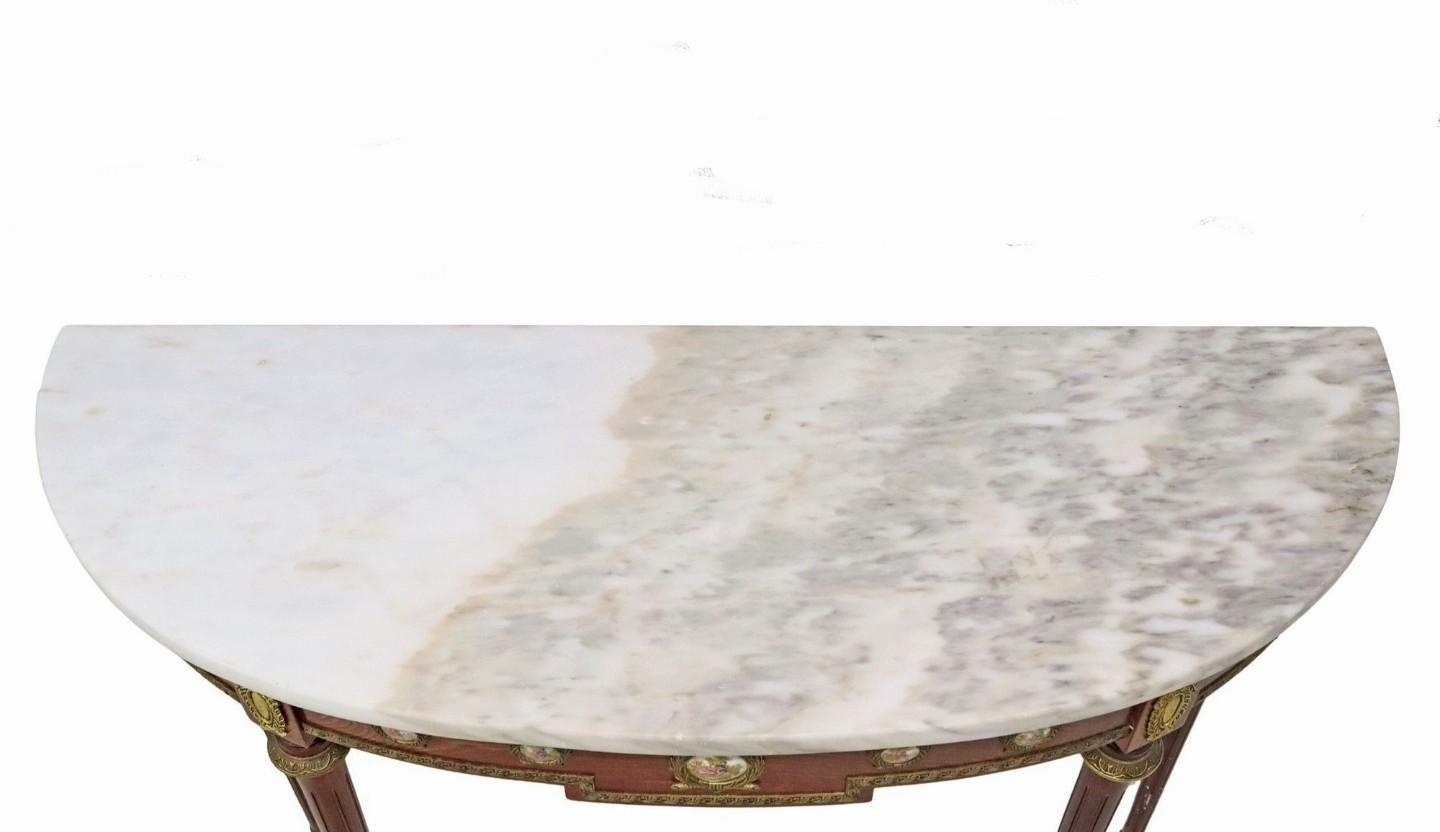 Console en bois massif richement figuré de style Louis XVI, montée sur bronze doré et porcelaine, par Harry & Lou Epstein (H & L Epstein, London).

Fabriqué à la main en Angleterre dans la première moitié du XXe siècle, il est exceptionnellement