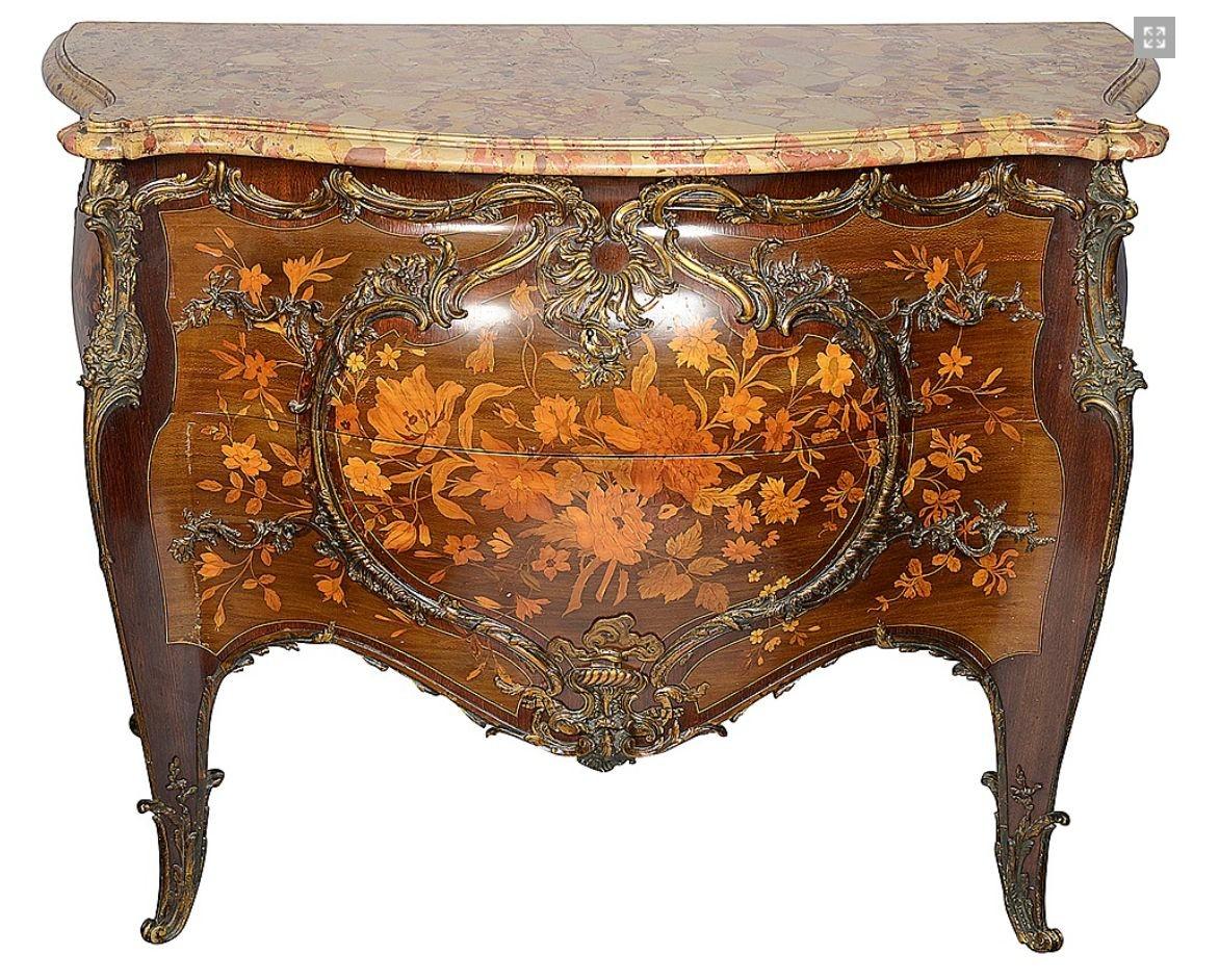 A fine quality French Louis XVI style bombe shaped commode with its original Breccia marble top, a serpentine moulded edge. Exquisite floral marquetry to the two drawers and sides, gilded ormolu rococo influenced scrolling foliate mounts and raised