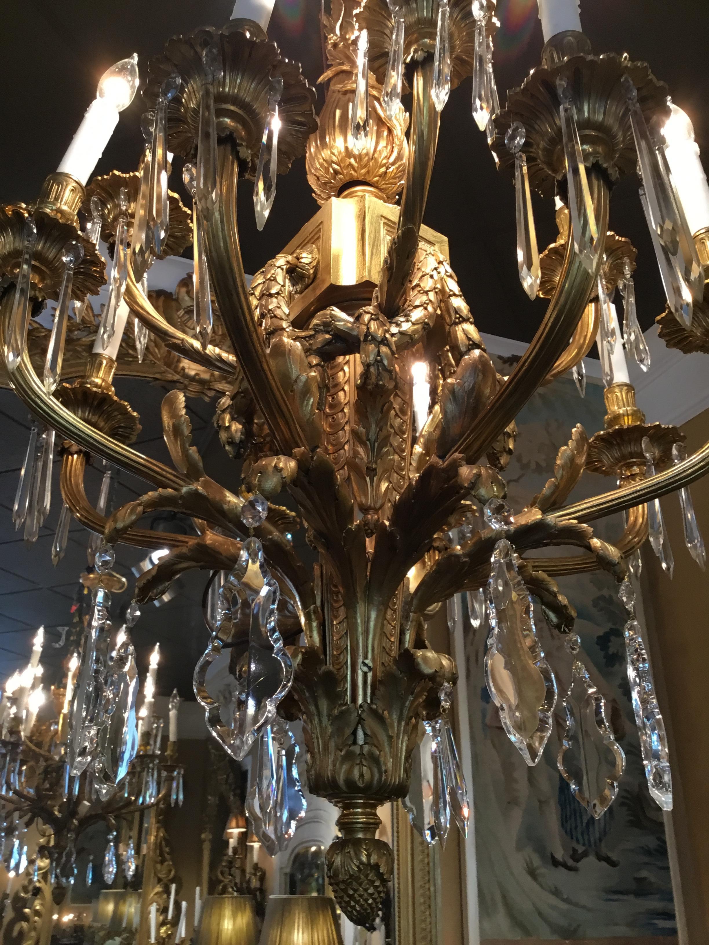 Exquisite gilt bronze chandelier with a rectangular stem cast with vertical
bands issuing acanthus leaves supporting serpentine
reeded branches ending in circular bobeches and vasiform nozzles
beneath a paneled block form capital suspending