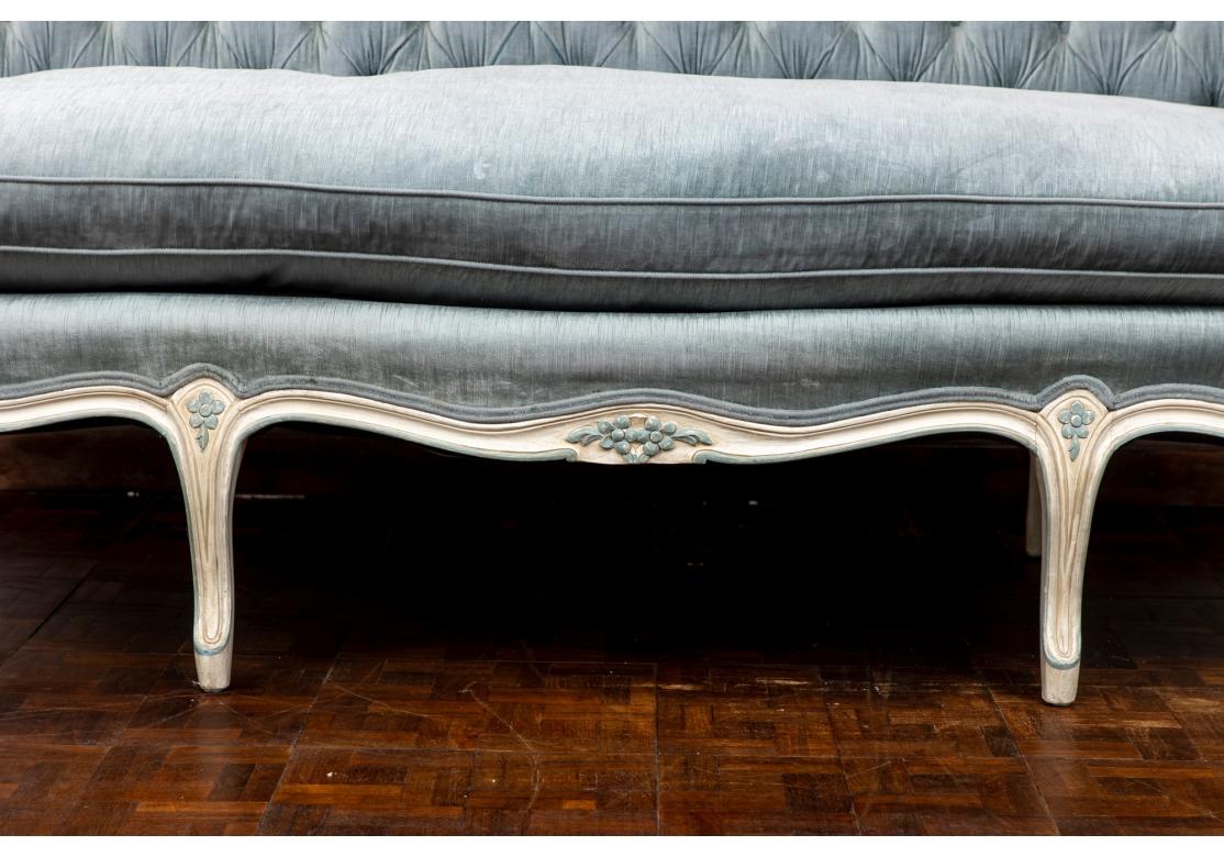 Ursprünglich gekauft bei W. & J. Sloane in der Fifth Avenue, New York City. Ein dramatisches und theatralisches Sofa im französischen Stil mit einem creme- und zeladonblau gestrichenen Rahmen mit einer geschnitzten Blumenspritze in der oberen Mitte