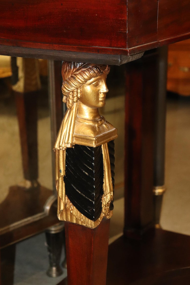 This is a superb and fine quality Egyptian revival console table in mahogany with bronze ormolu and fine gold leaf gilded figures at each support. The table is in very good condition and measures 38 tall x 20 deep x 38 wide and has a drawer. The