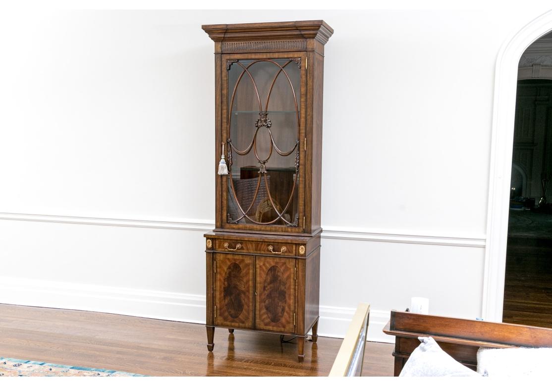 Eine Maitland-Smith-Vitrine aus dem 20. Jahrhundert im georgianischen Stil, fachmännisch konstruiert mit hell-, mittel- und dunkelbraunen Furnieren für ein stattliches Aussehen. Mit einer kannelierten Leiste über einem abgeschrägten Giebel, der eine