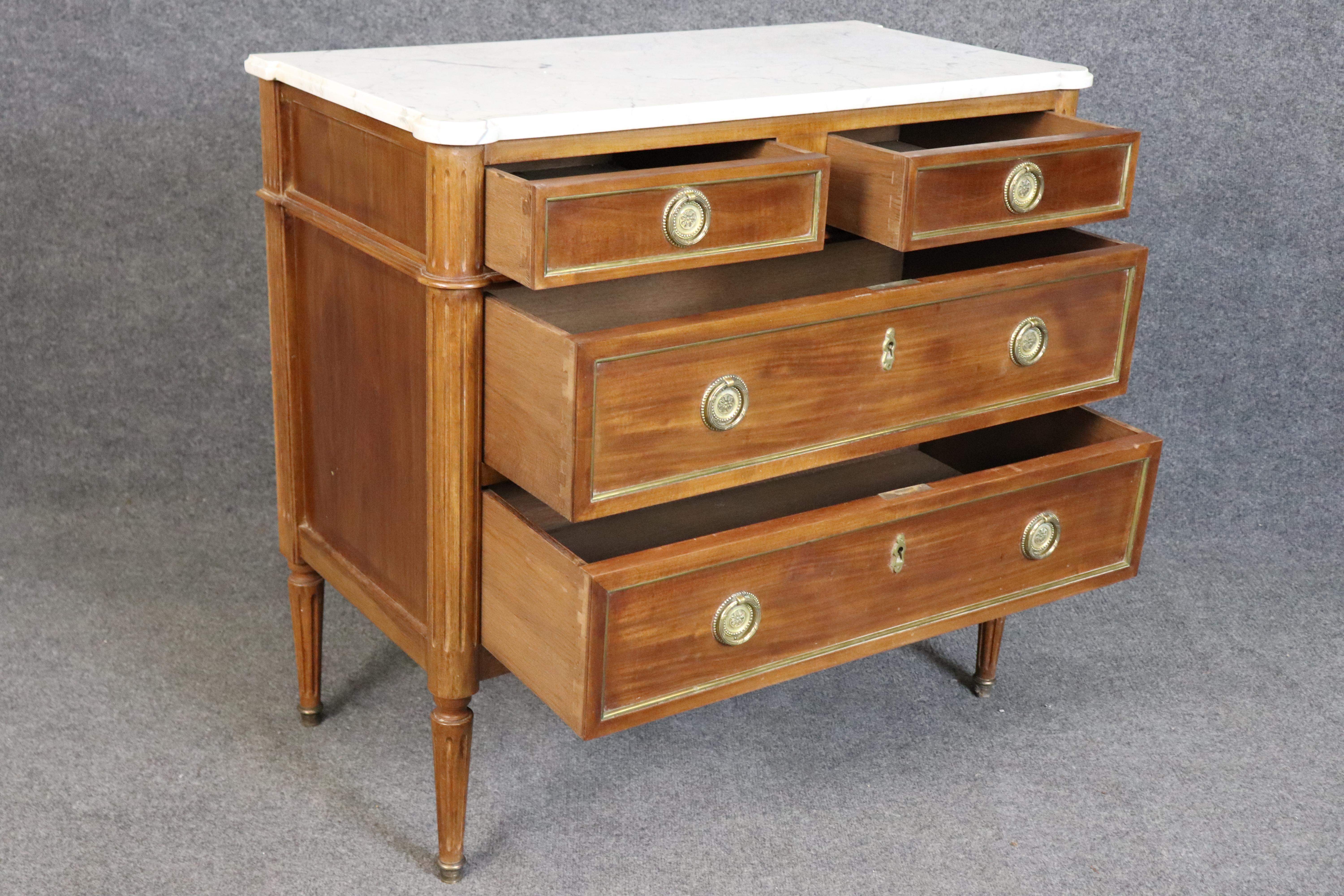 Lleva la refinada elegancia neoclásica a tu casa con esta soberbia cómoda francesa con encimera de mármol estilo Luis XVI o Directoire, un ejemplo intemporal de la artesanía francesa de finales del siglo XVIII. Cubierta con una losa de mármol blanco