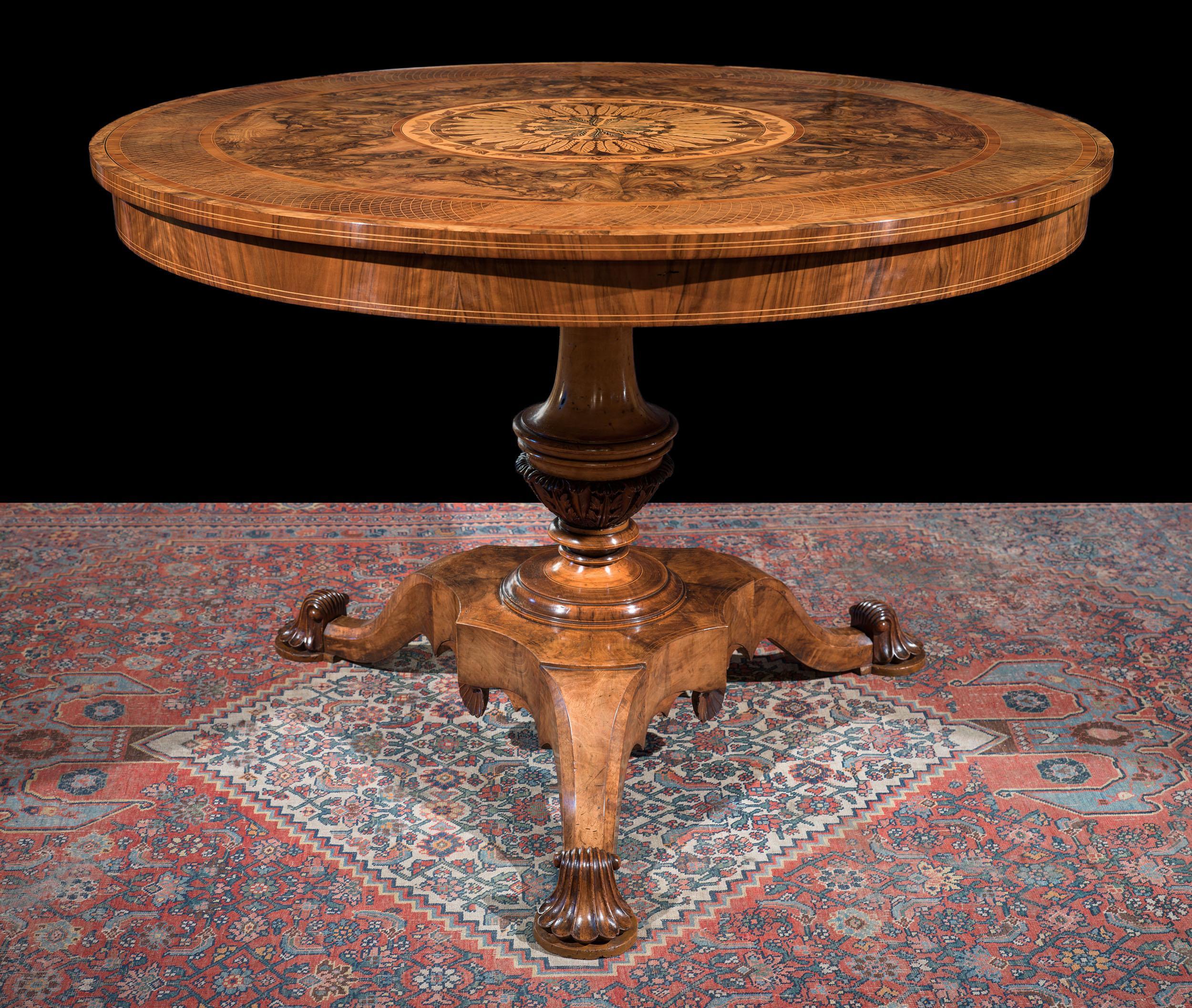 Une belle table centrale italienne avec un magnifique plateau composé de bandes concentriques de ronce de noyer assortie. L'anneau extérieur est délicieusement décoré d'une marqueterie de hachures, qui encadre une large bande de placage de ronce de
