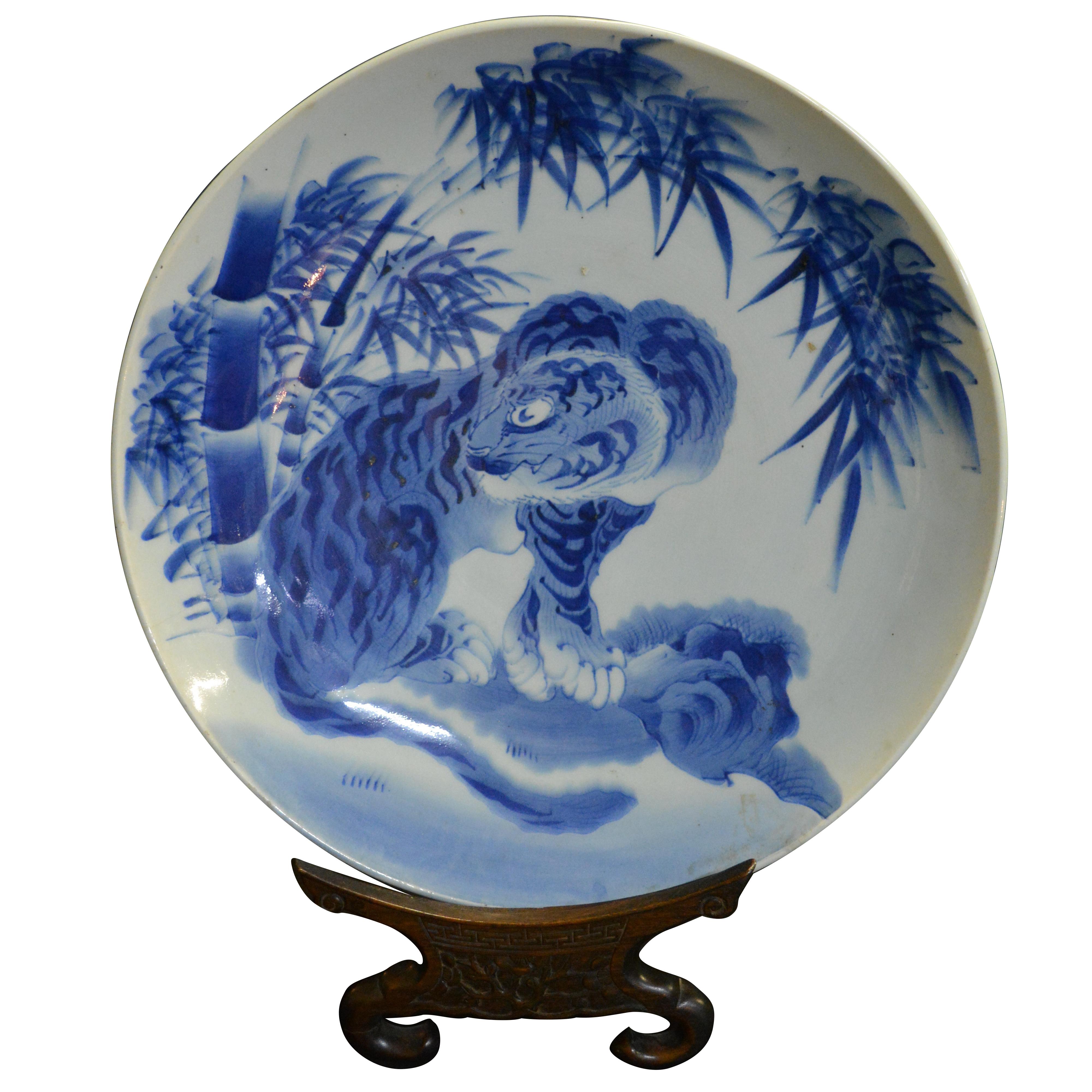 A charming very fine large Japanese porcelain charger. The thickly potted porcelain charger with underglaze landscape decoration, a Korean stylized tiger in landscape of graceful bamboo, unmarked. Stand not included.

Provenance: Assembled from our