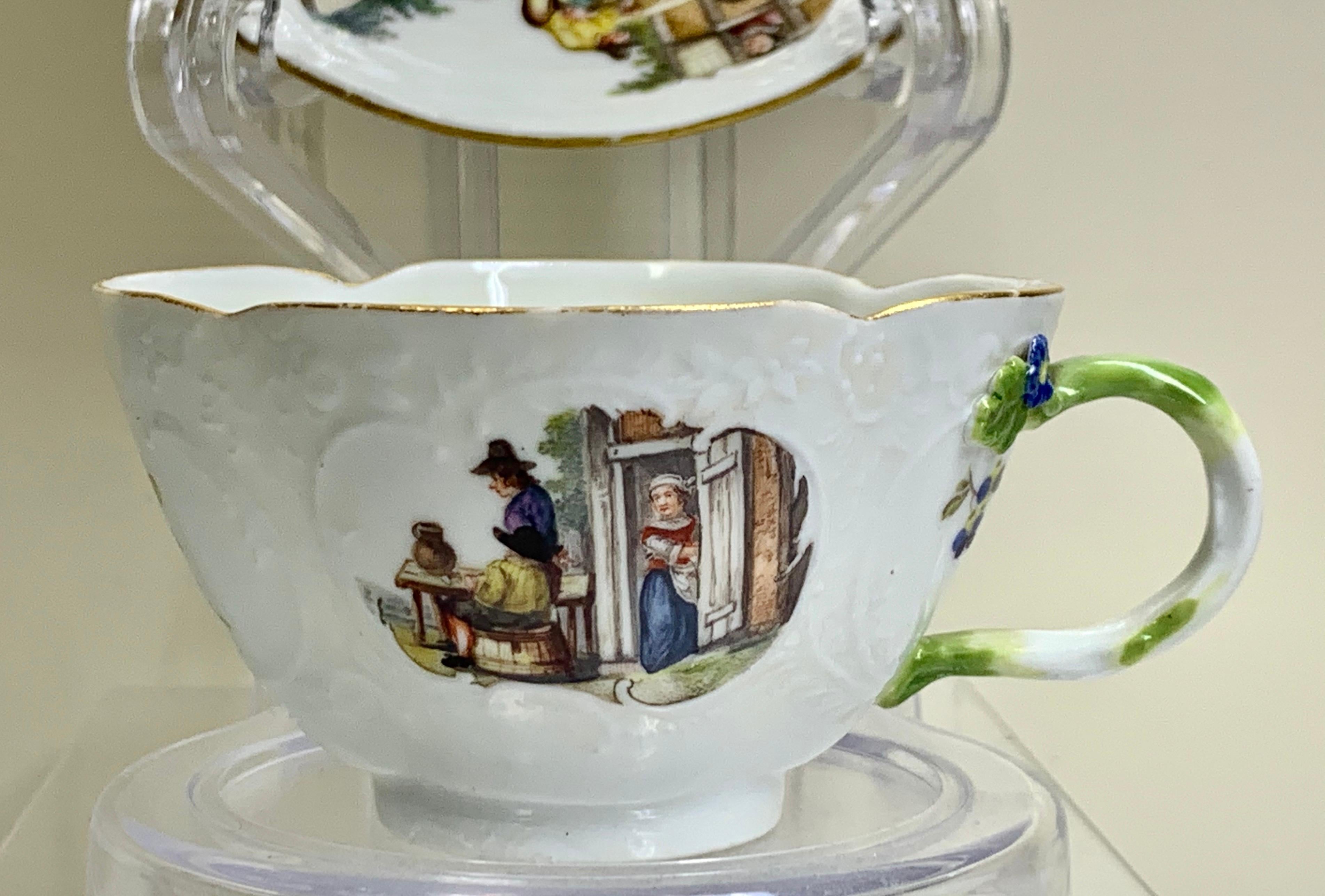 A stunning quality Meissen teabowl and saucer, superbly painted with Watteauesque scenes
This Meissen cup & saucer, moulded with fine Rococo panels carefully painted with scenes
in a garden, superb relief moulded trim and all around the rims with