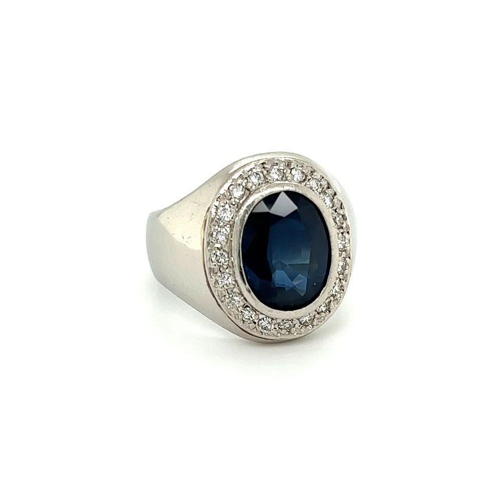 Handsome High Quality Gent’s Platinum Ring. Centering a securely nestled Hand set Oval Blue Sapphire, weighing approx. 5.46 Carats. Surrounded by Diamonds, approx. 0.41tcw. Hand crafted Platinum mounting. GIA #5234057261. Ring size 8.5, we offer
