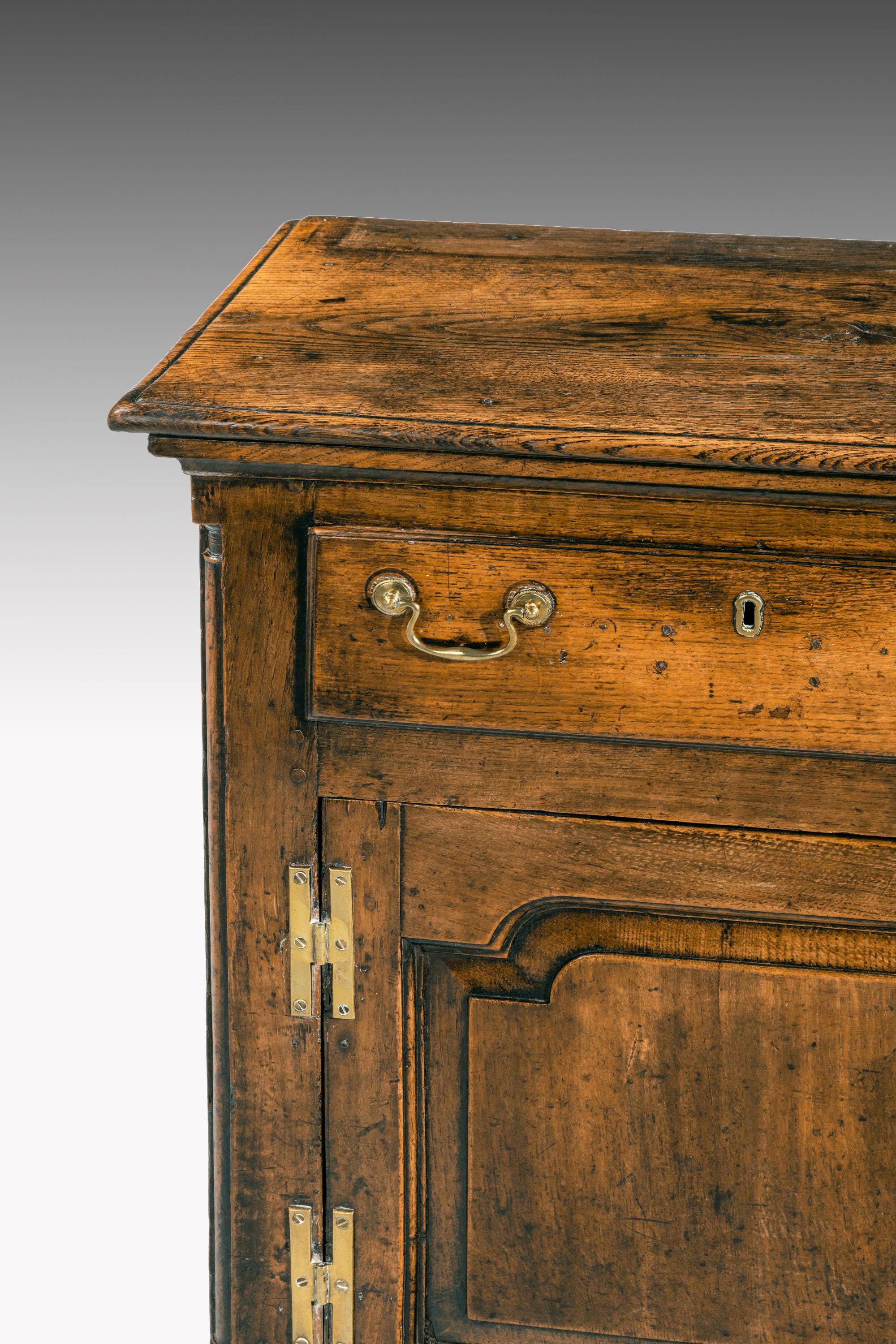 A particularly fine mid-18th-century oak dresser of quite outstanding color and patina. It retains its original swan neck handles. A very narrow piece of oak.
 
