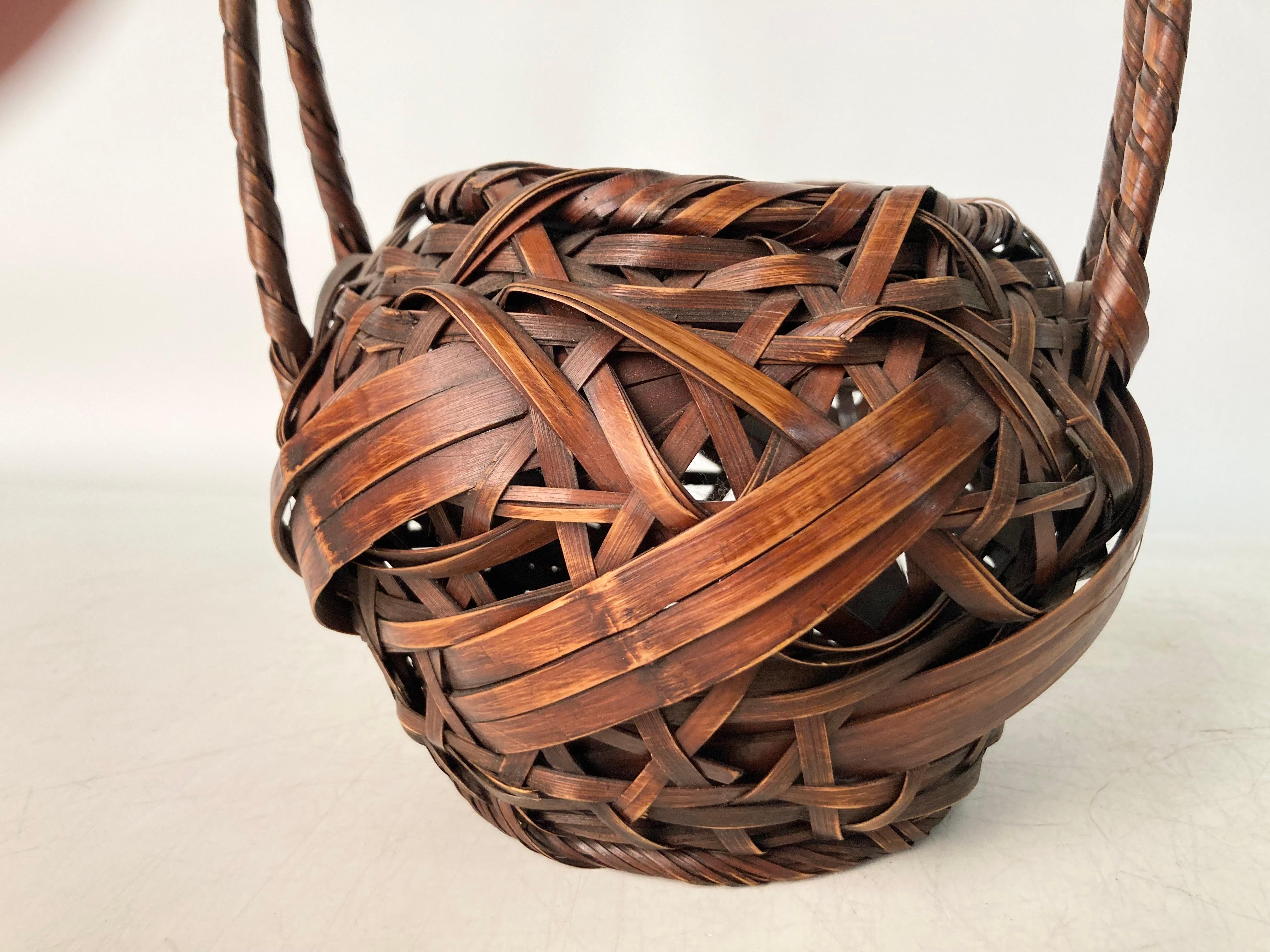 A finely crafted split and stained bamboo handled Ikebana Basket with fine traditional form. The Basket with a strong weave in a mix of wider and slender elements creating a captivating rhythm and in a fine deep stain. 

Dimensions: 11.5” high by