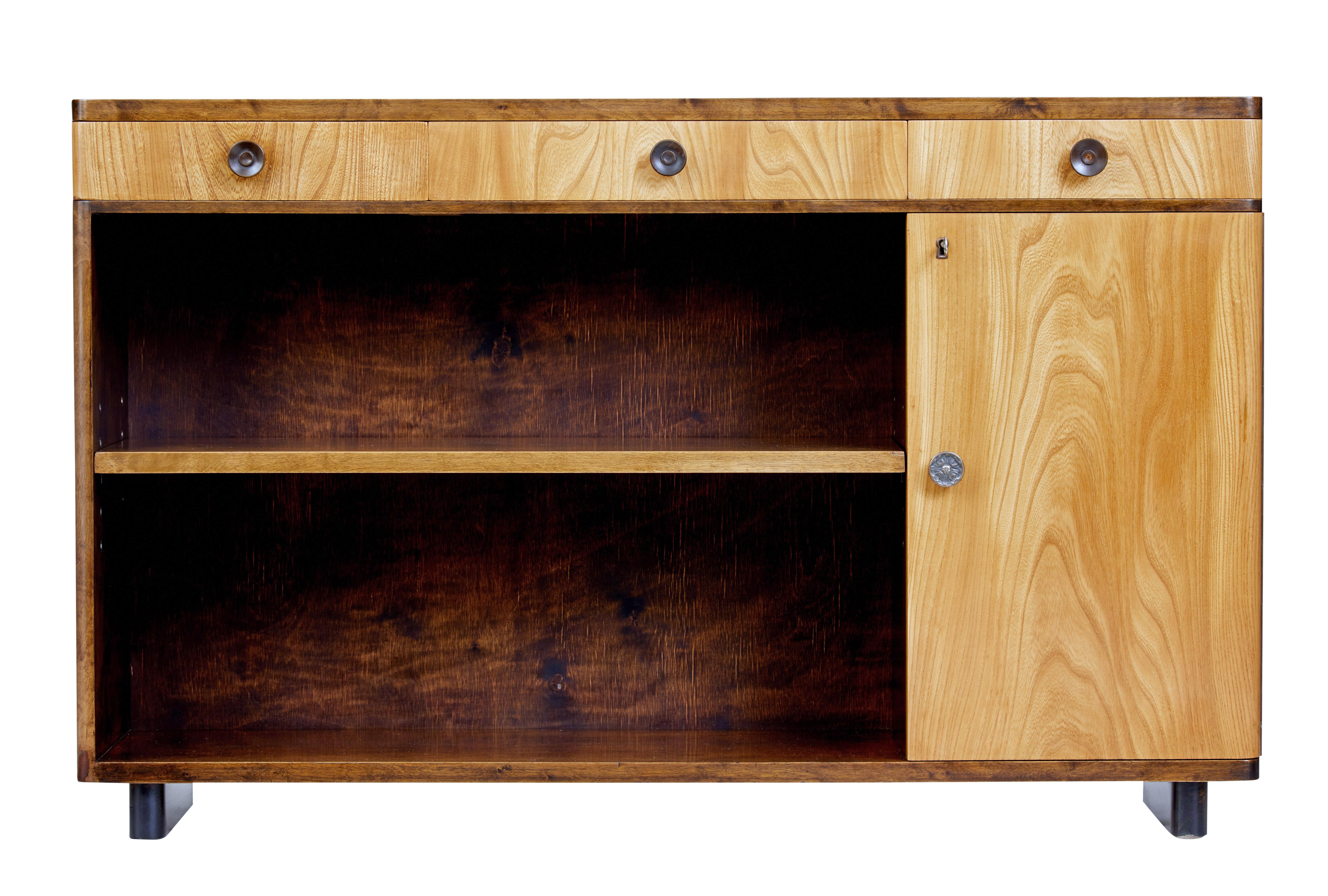 Fine mid-20th century Scandinavian elm and birch low bookcase, circa 1940.

Fine quality late art deco low bookcase.

Beautifully presented in a dark birch with light elm doors and drawers.

3 drawers under the top surface with turned wooden