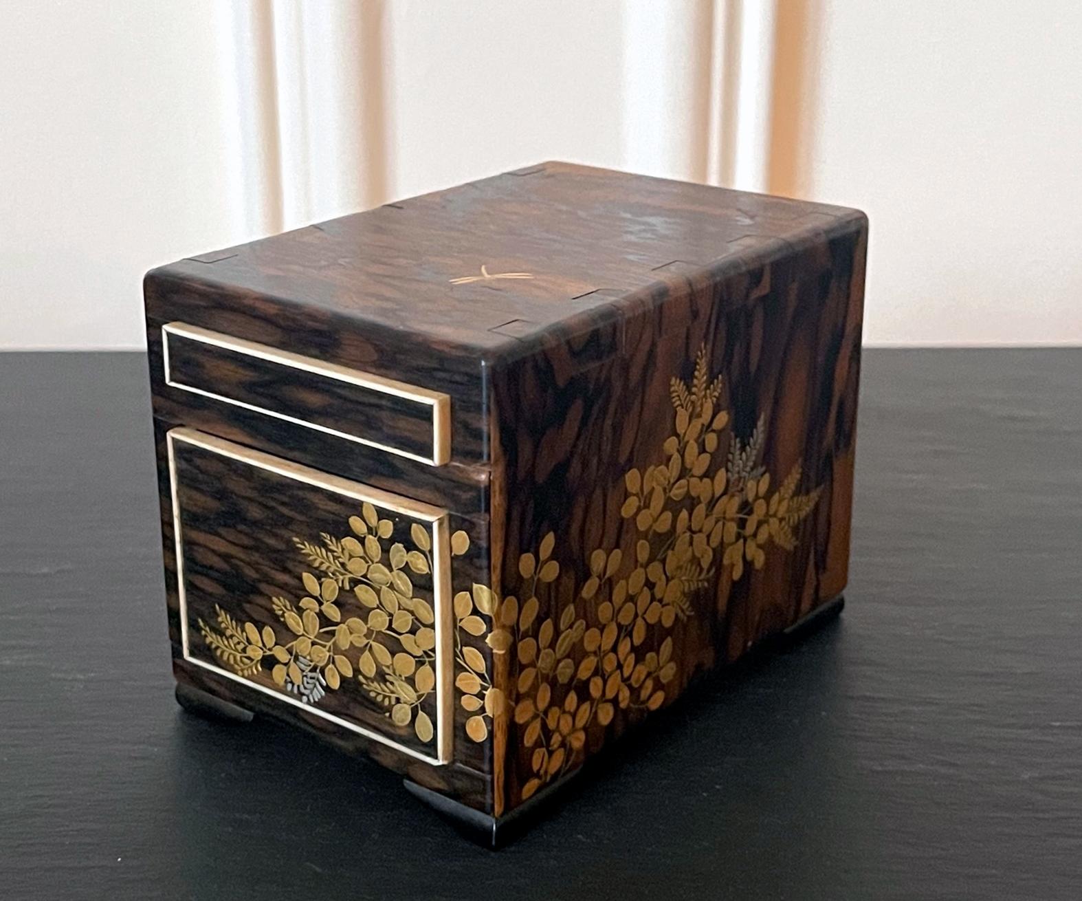 A fine Japanese miniature kodansu constructed from Kaki wood (Persimmon) circa 19th century, late Meiji period. With its expressive exotic wood grains and exposed tenon construction, the small table-top chest with two outlined drawers showcases fine