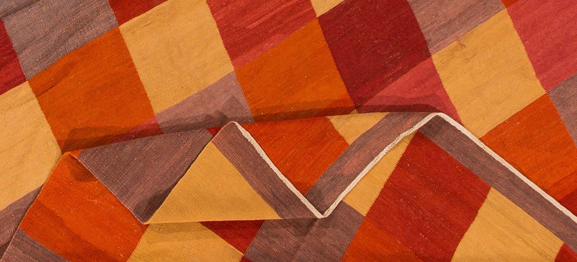 Schöner moderner (2015) türkischer Kelim-Teppich. Mehrfarbiges, geometrisches Patchwork-Muster auf einem leicht strukturierten Feld mit einem dünnen braunen Rand an zwei Kanten. Maße 8,07x11,08.
