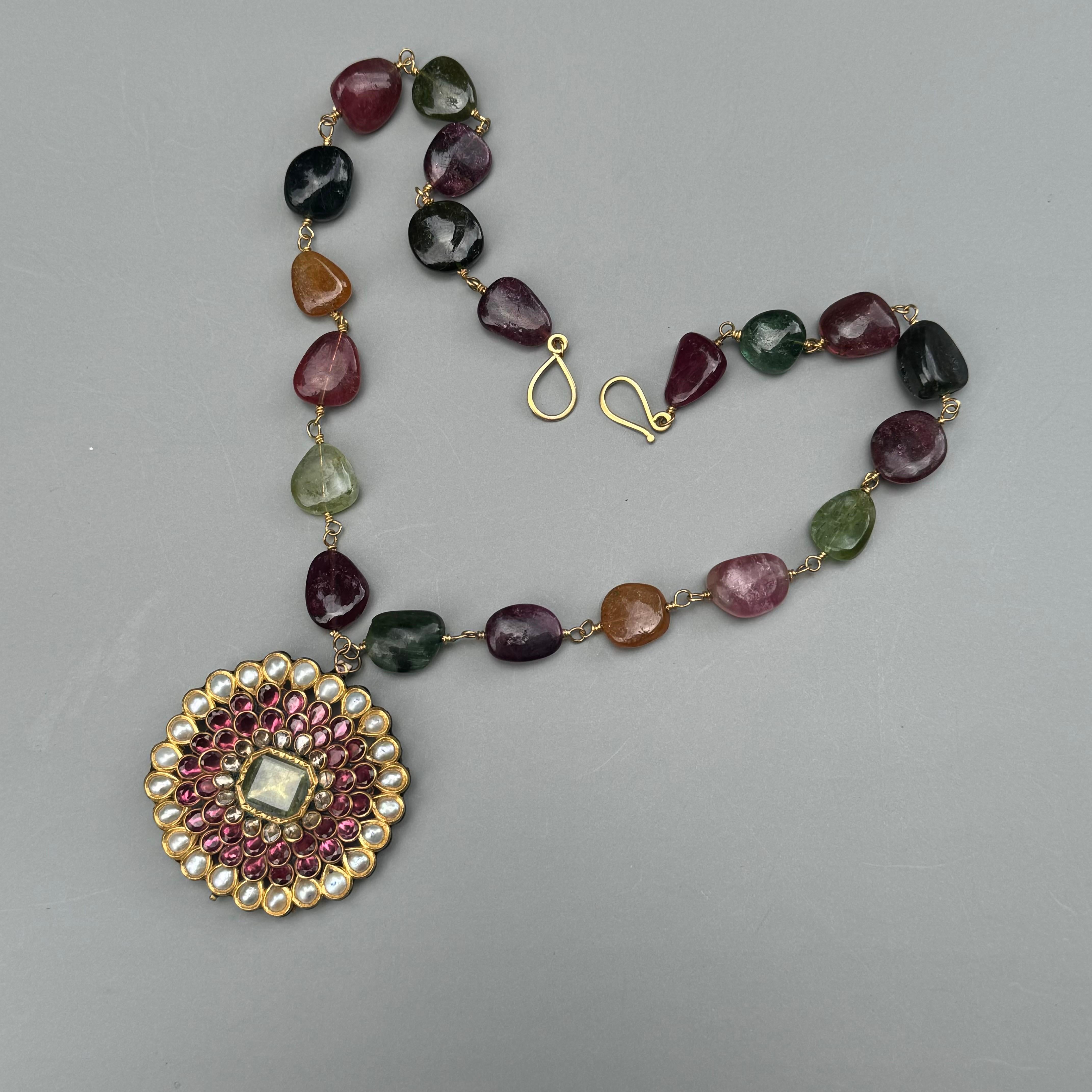 Step into a world of timeless elegance with our Fine Mughal-style Indian Gold Tourmaline Pearl Diamond Pendant Necklace. Inspired by the opulent traditions of the Mughal empire, this exquisite necklace combines the richness of gold with the