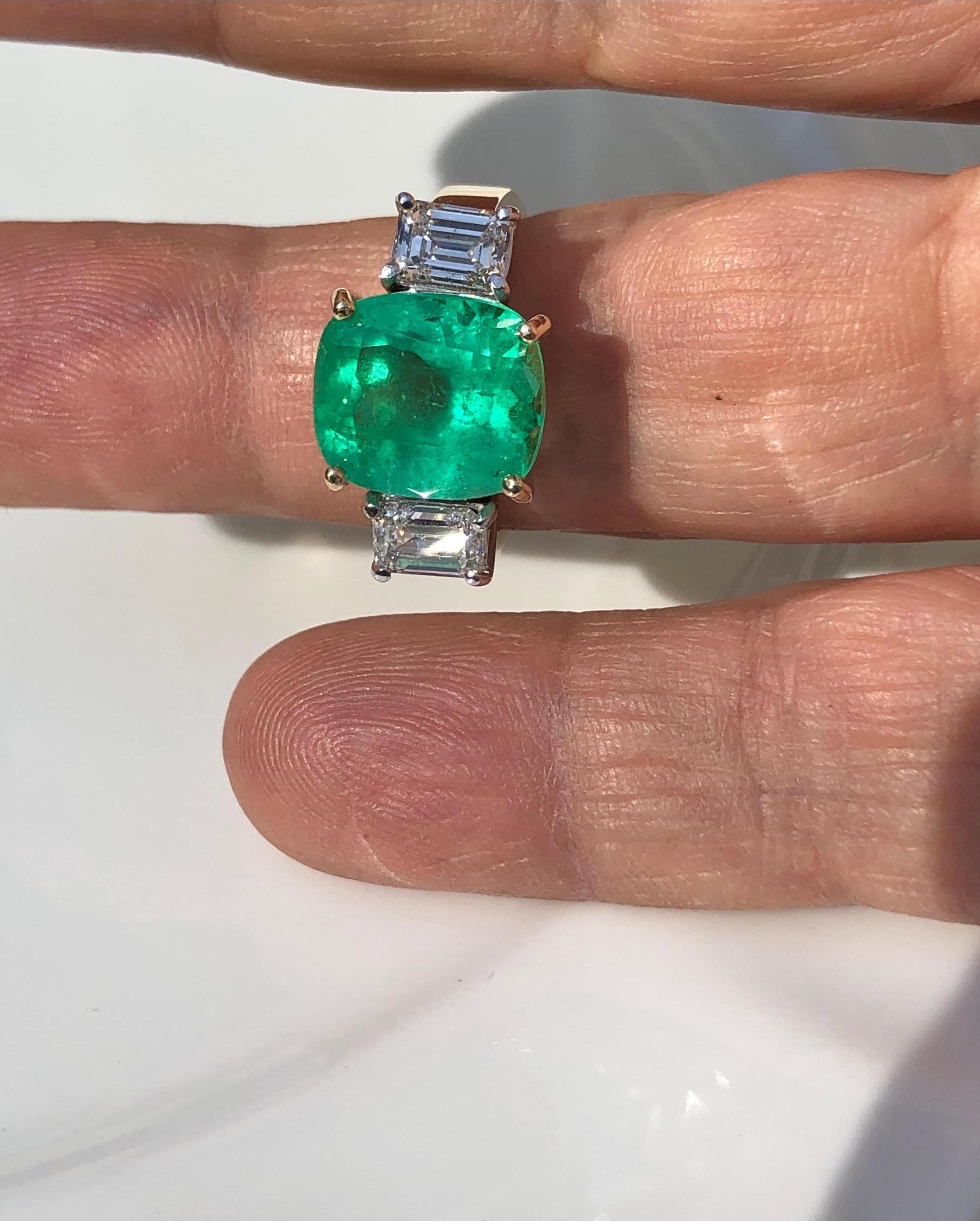 Fine Natural Colombian Emerald Cushion Cut 5.49 carat, medium green, very good clarity & transparency. Accented by natural two emerald cut diamonds weighting 1.41 carat SI2/ F/G. yellow gold and diamonds set in white gold. Ring Size 7.  each diamond