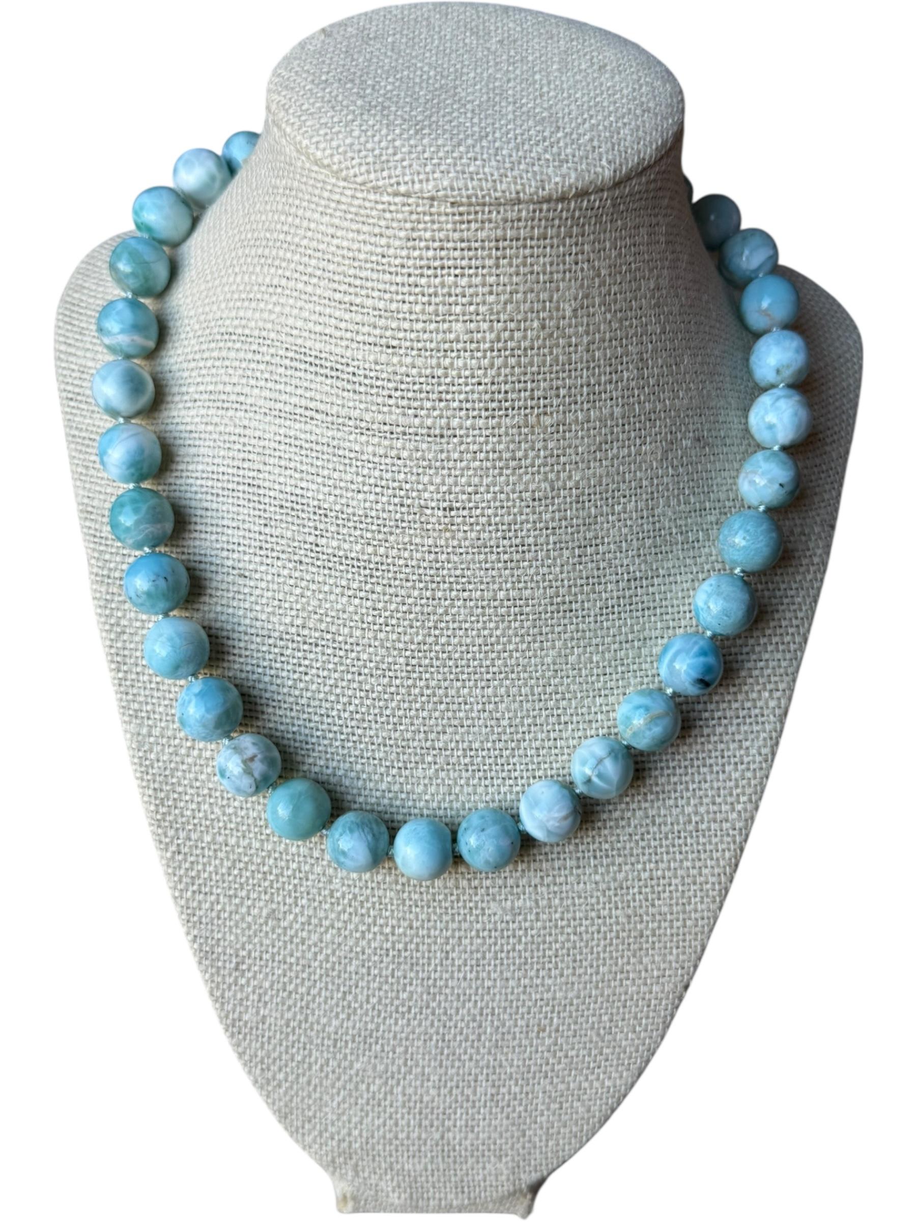 Un filo radioso di Larimar dominicano da 12 mm, selezionato a mano per la sua luminosa tavolozza di blu cielo, la morbida marmorizzazione a nuvola e l'eccezionale rotondità. Ogni perla mostra il caratteristico bagliore caraibico che contraddistingue