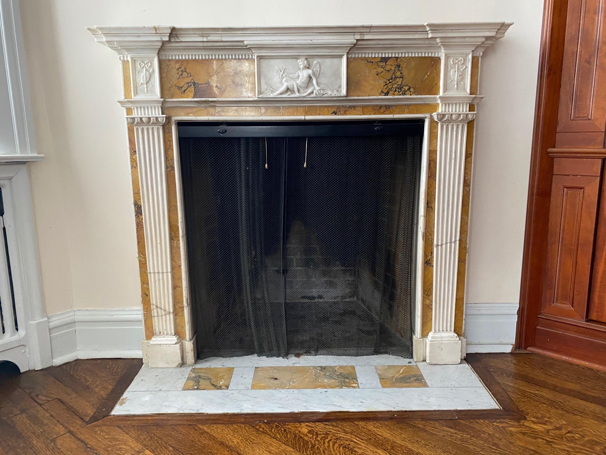 Exquisite Georgian period , white statuary and siena marble fireplace mantel, featuring beautifully carved Neo-Classical attributes , the center cartouche depicting a cherub Cupid playing with a dragonfly.
Interior dimensions: H:35.25 x L:33.5