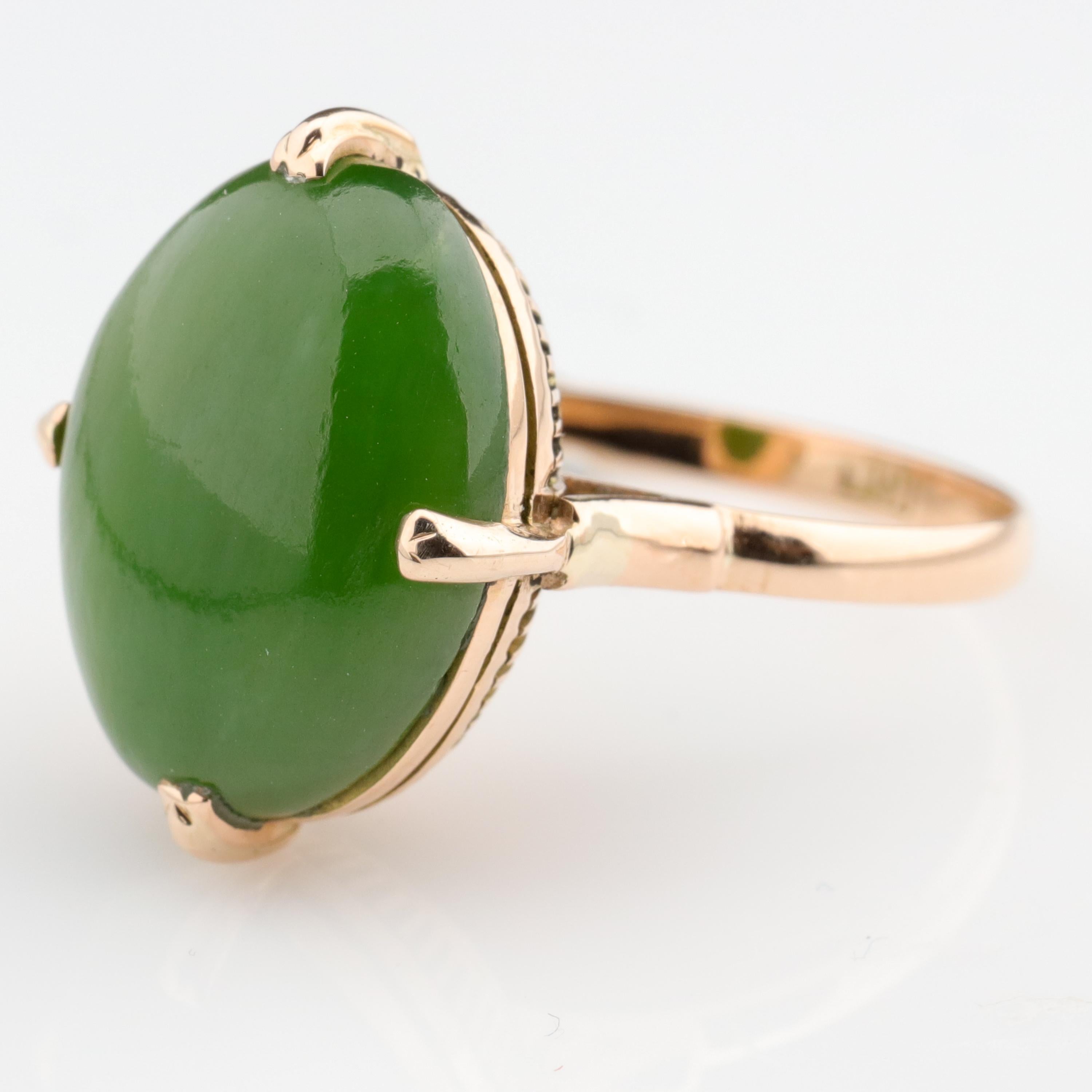 Featuring a high-quality, translucent  15.77 mm x 11.93 mm natural and untreated nephrite jade cabochon with its gorgeous, original and unadulterated polish, this Victorian-era 14k rose gold ring is just about as superb a Retro-era nephrite ring as