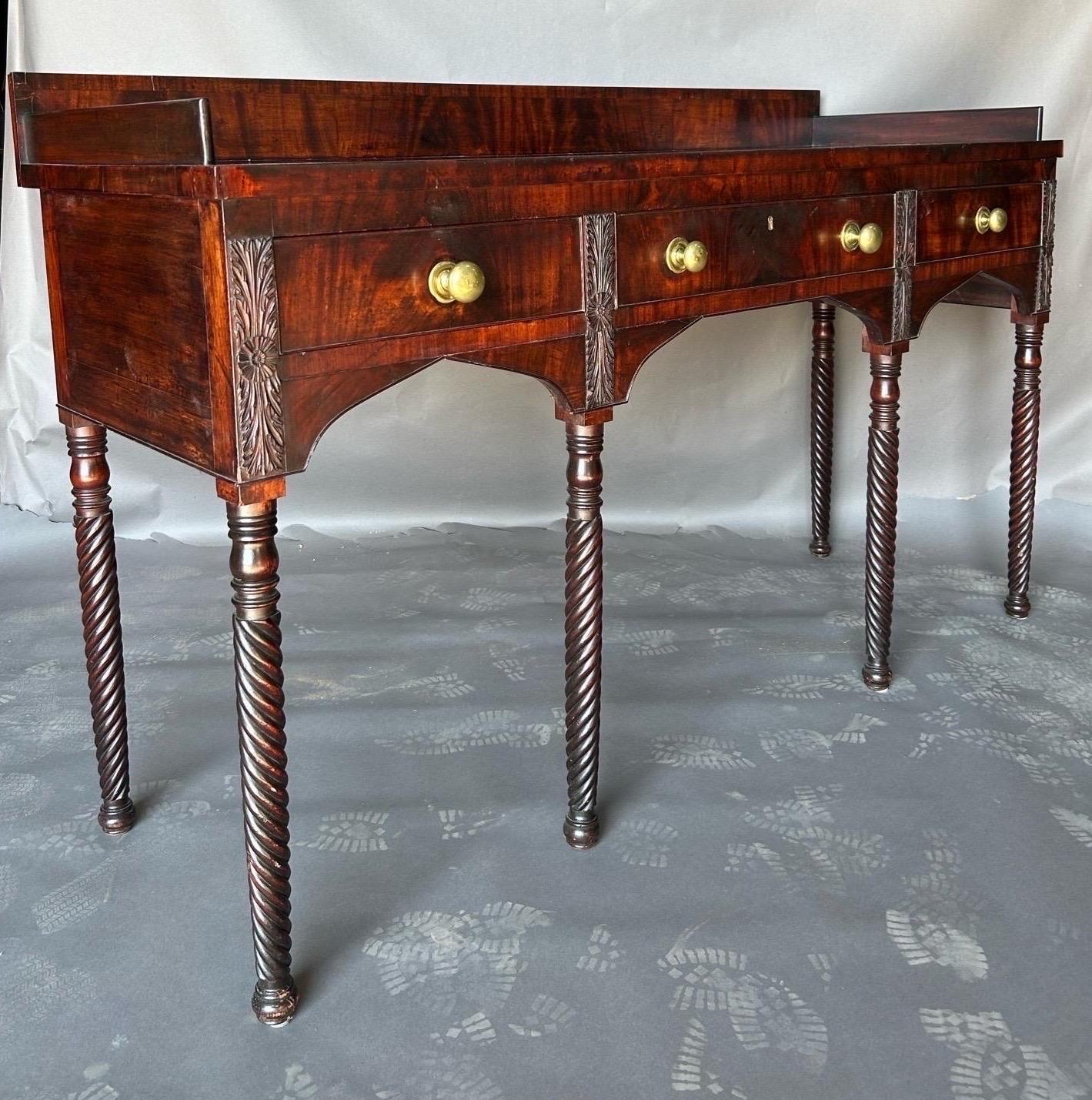 Fine early 19th century American Federal period mahogany sideboard from Norfolk, Virginia. The sideboard features 
carved leaf and rosette motifs over spiral turned legs and button feet. It’s a very fine example of the period. 