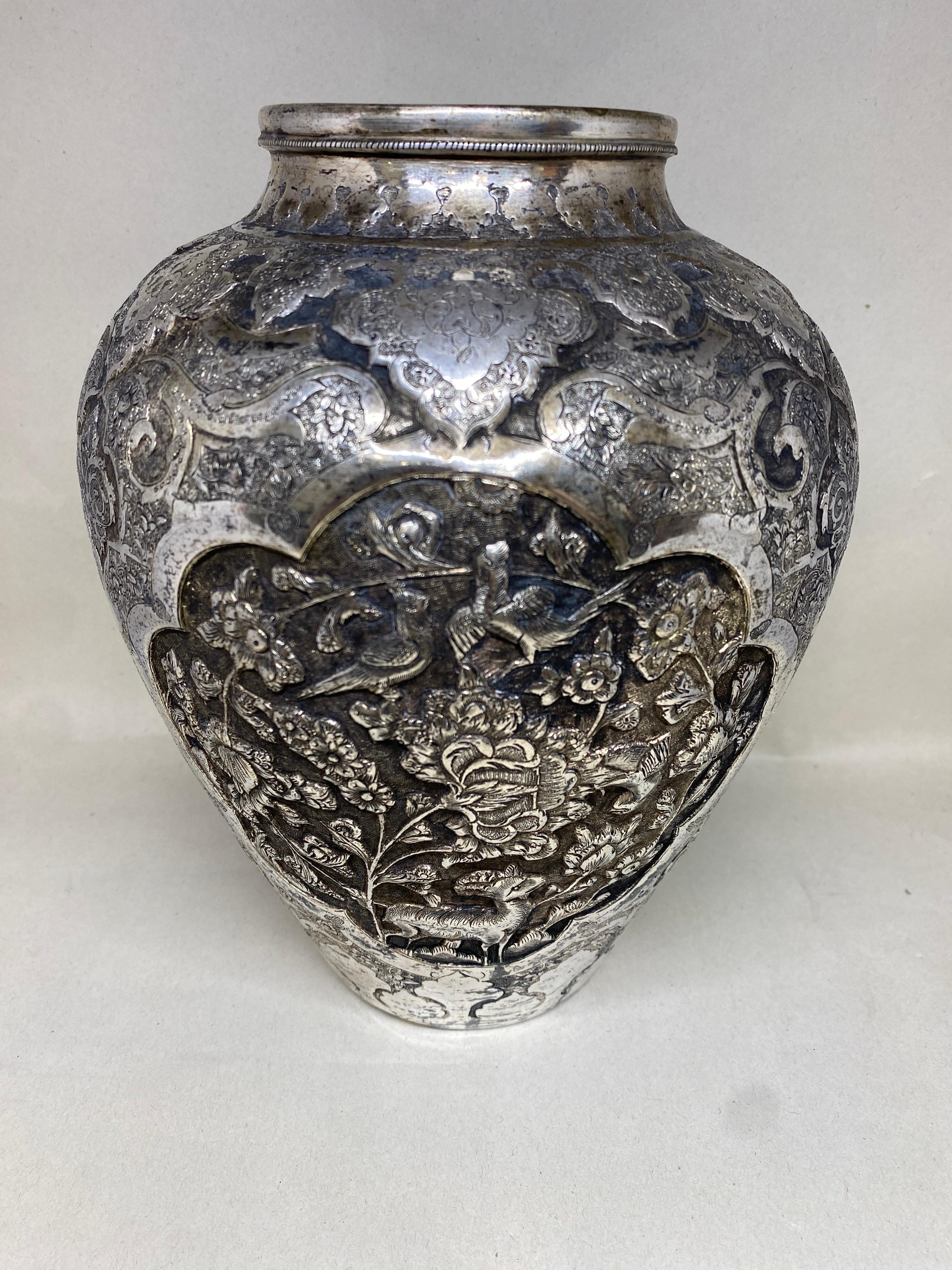 Eine feine alte oder antike islamische persische Silbervase.

Reich verziert mit dem unverwechselbaren Ishafan-Stil.  Es weist ein graviertes, ziseliertes, stilisiertes Blumen- und Blattwerkdekor auf, das figurale Repoussé-Szenen mit Vögeln, Blumen,