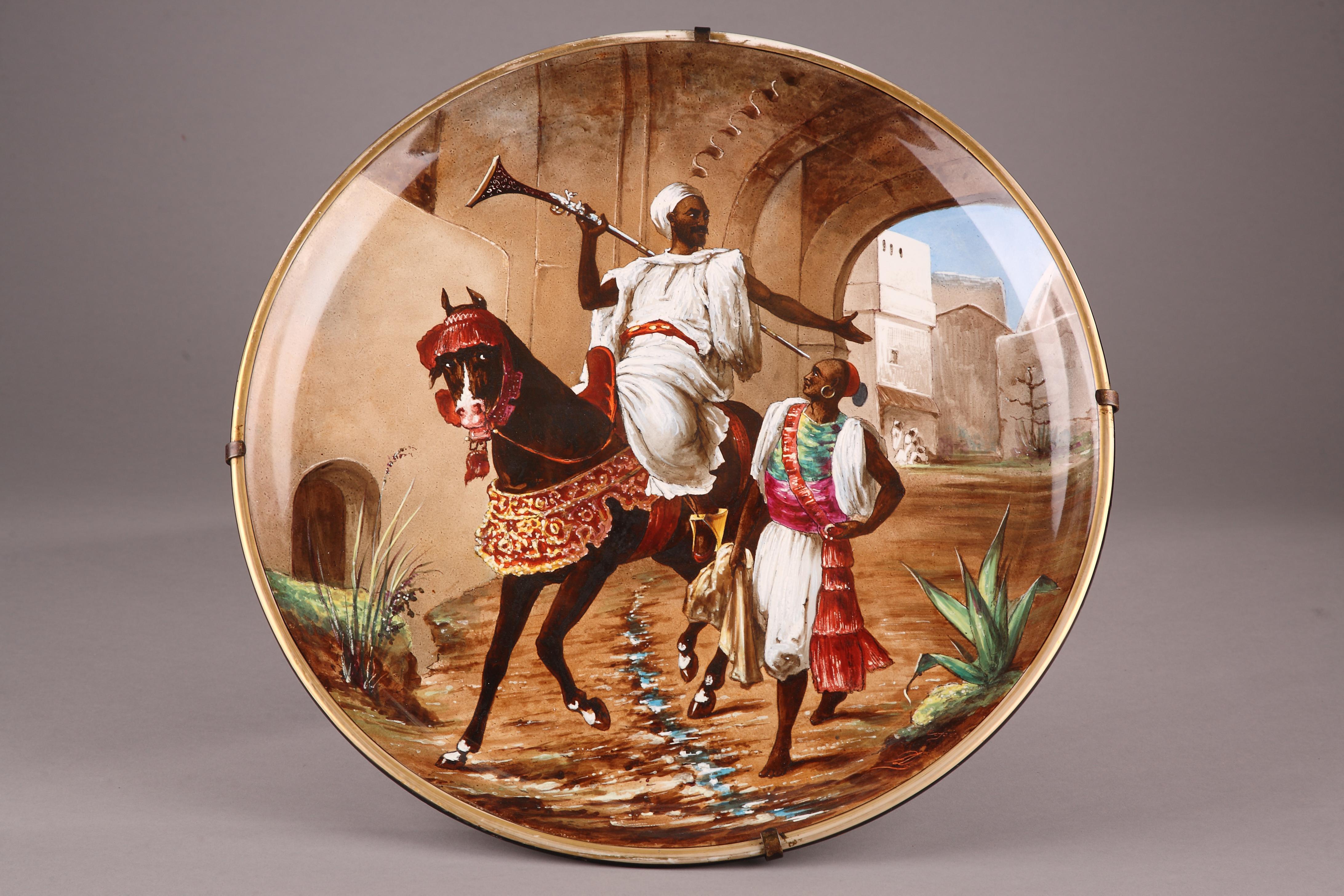 Signed by Cojoie AD, the decor-painter
and on the reverse, LM et Cie, the making mark of the manufacture

A circular hand painted pottery charger, decorated with an orientalist scene depicting an Arab ridder and his servant getting out of a town.