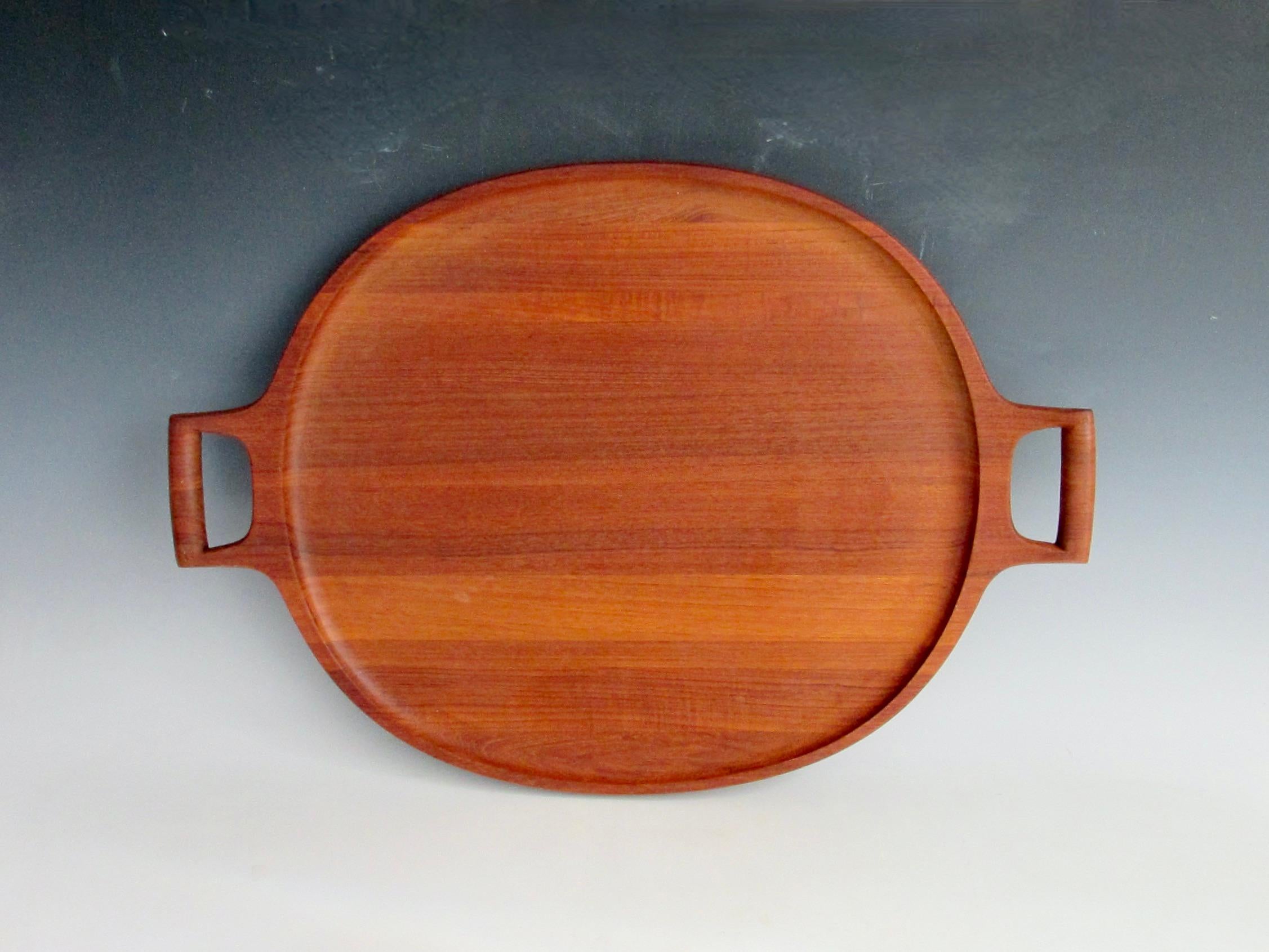 The best and possibly largest  two handle Teak Serving Tray by Jens Quistgaard for Dansk Denmark   . Very clean original no cracks or bruise . Little evidence of previous use . Stamped Dansk Designs Denmark JHQ with three duck logo .
To quote Dansk 