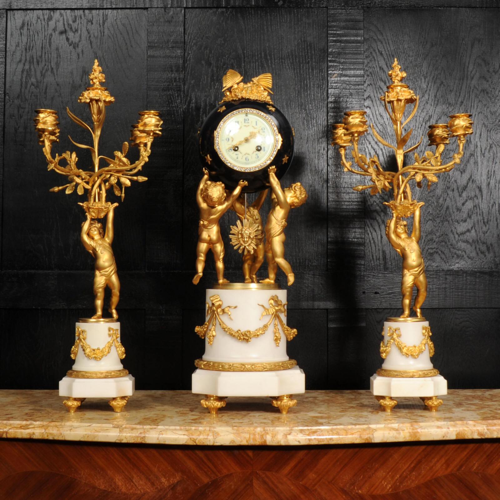 A large and magnificent clock set by the renown bronze founder H Luppens of Brussels. Classically modelled in the Louis XVI style, the clock features three ormolu cherubs toiling to support a large deep blue lacquered orb that contains the clock