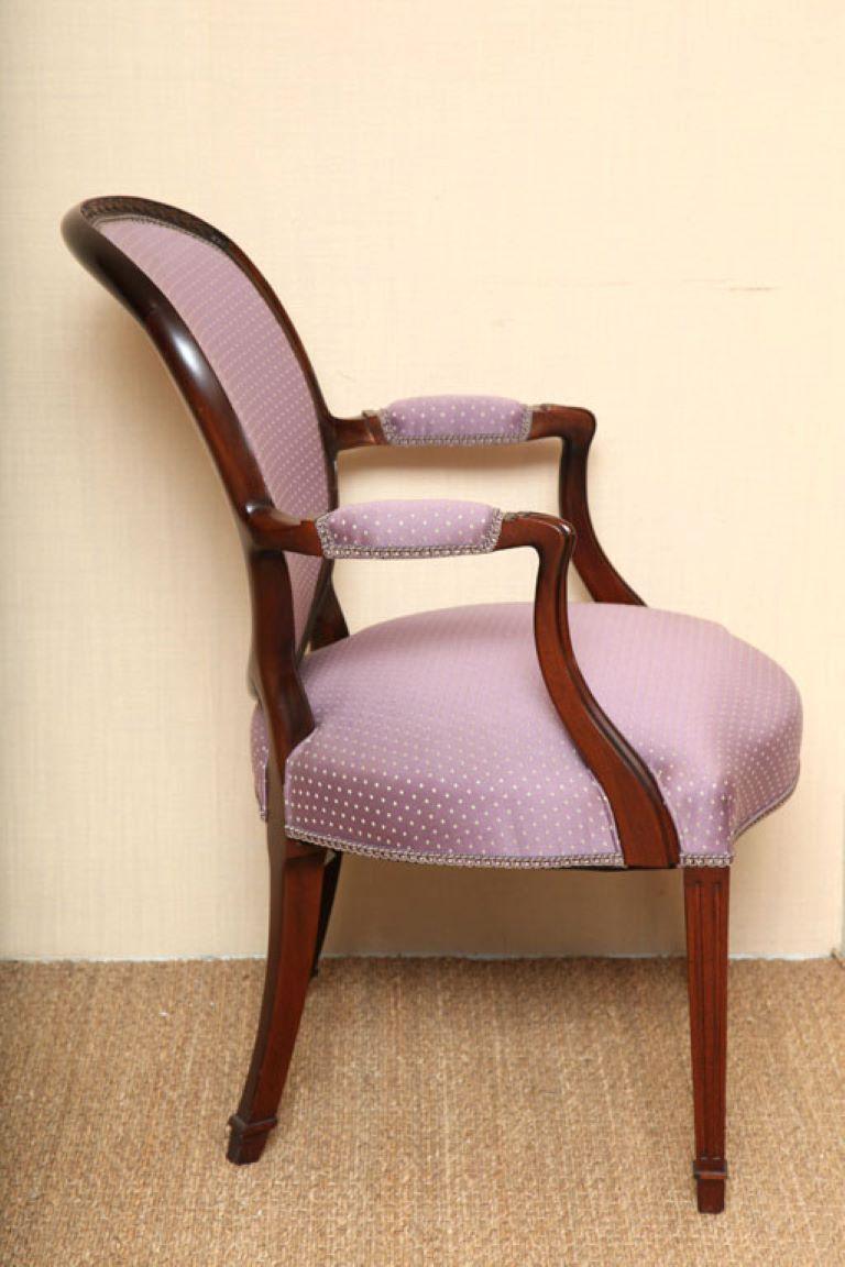 The most exquisitely shaped oval-back Wood & Hogan upholstered armchair. The subtle convolution of the curved back, with its delicate foliage carvings, could have been fashioned only by a master. 

A perfect blend of Mahogany and fabric, it is an