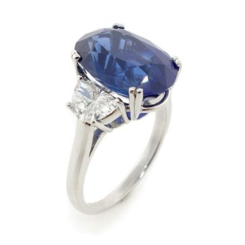 GIA certified VVV Fine Oval blue Sapphire of about 9.62 carats measuring 14.34×10.01×7.61mm. The sapphire has Two 1/2 moon Diamonds of about 1.02 carats on the sides with a clarity of VS and color G (0.50ct 6.82×4.56×2.48 and 0.52ct 6.79×4.66×2.58).