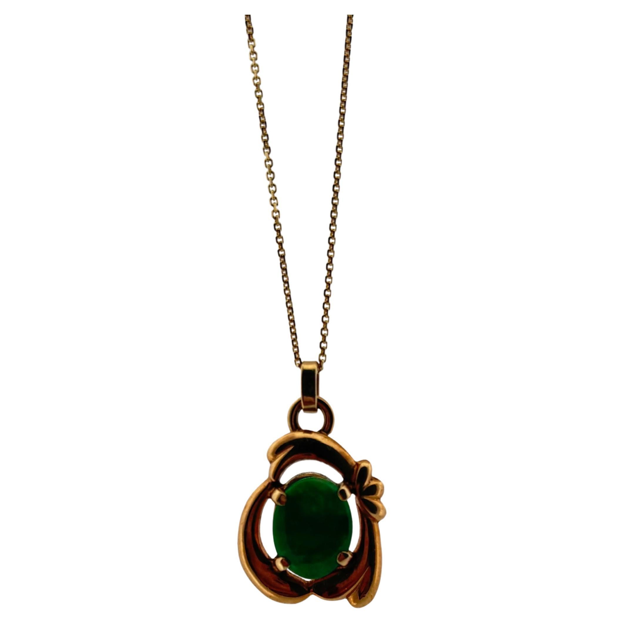 This elegant pendant is crafted in 14k yellow gold and features a richly colored natural jade cabochon, cut into an oval shape measuring 9mm long by 7mm wide. The vivid green hue of the jade exudes a timeless sense of balance and vitality,