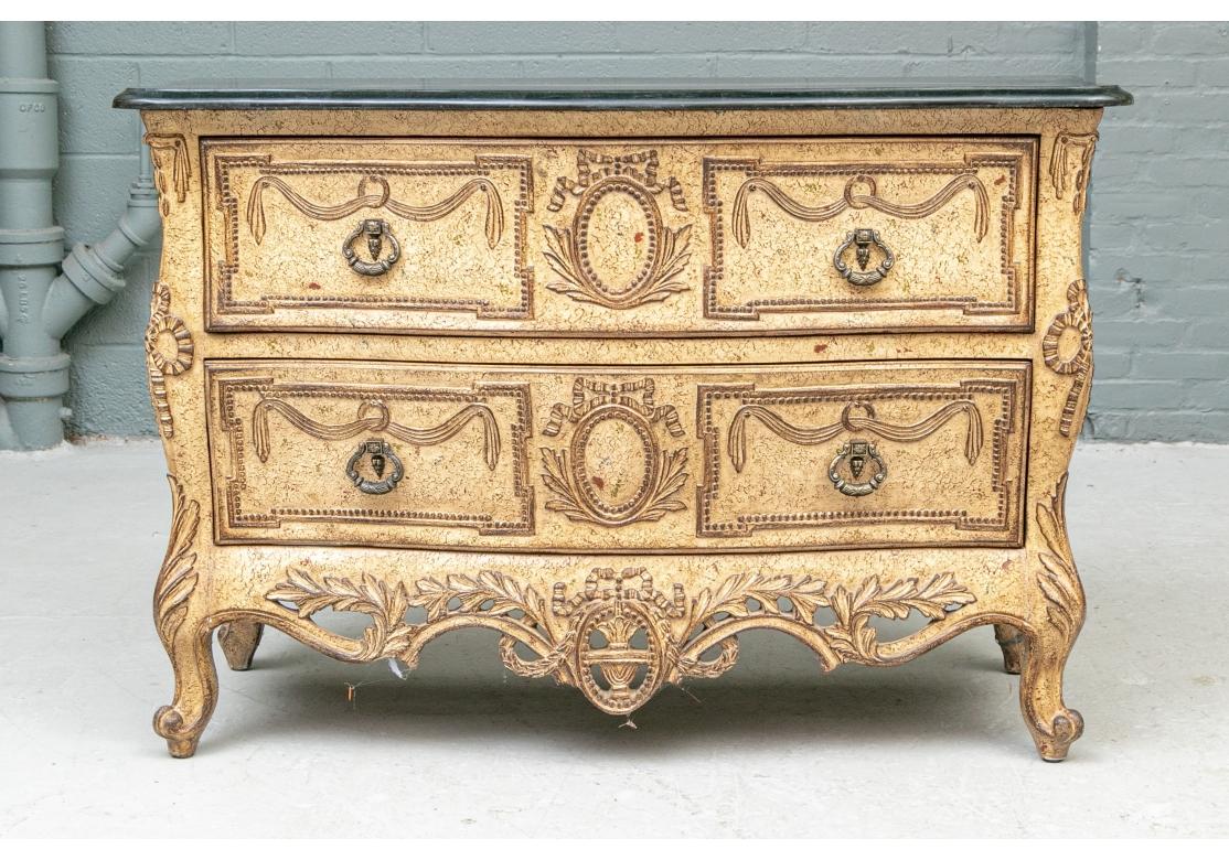 An Italianate design bombe chest in a speckled finish in black and red on pale tan. With carved neoclassical motifs- swags on the drawers, bows and ovals in between, and complementary openwork carved skirt rail with leaves and oval. With heavy brass