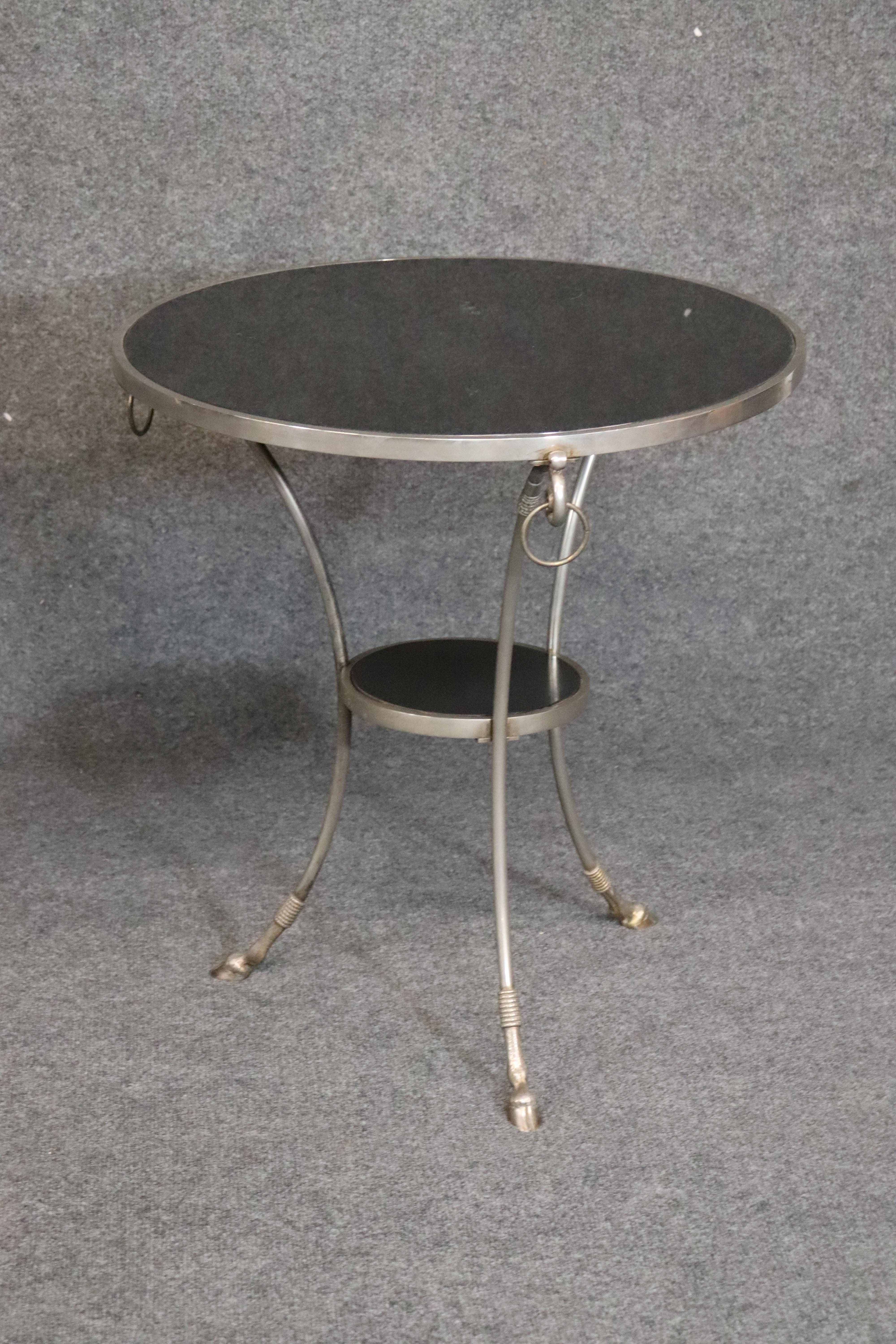 This is a fine pair of guerdions with black granite or marble tops and strong and sturdy bases. They are in good original condition. The tables measure 26.75 inches tall x 25 inches wide x 25 inches across.