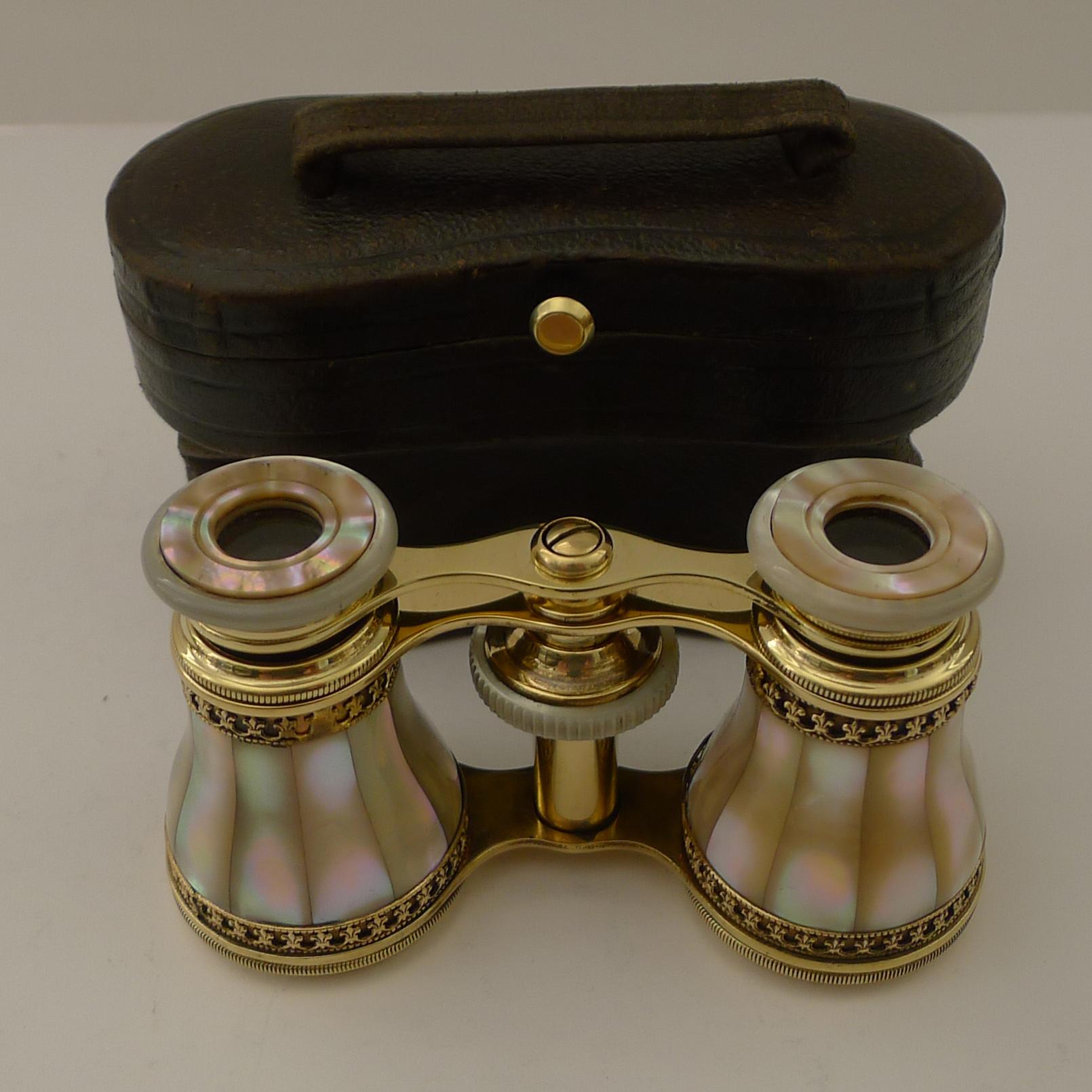 A superb pair of early twentieth century opera glasses clad in iridescent Mother of Pearl or Nacre shell and decorated with Fleur de Lys filigree borders to top and bottom.

They have been meticulously and professionally cleaned and polished,
