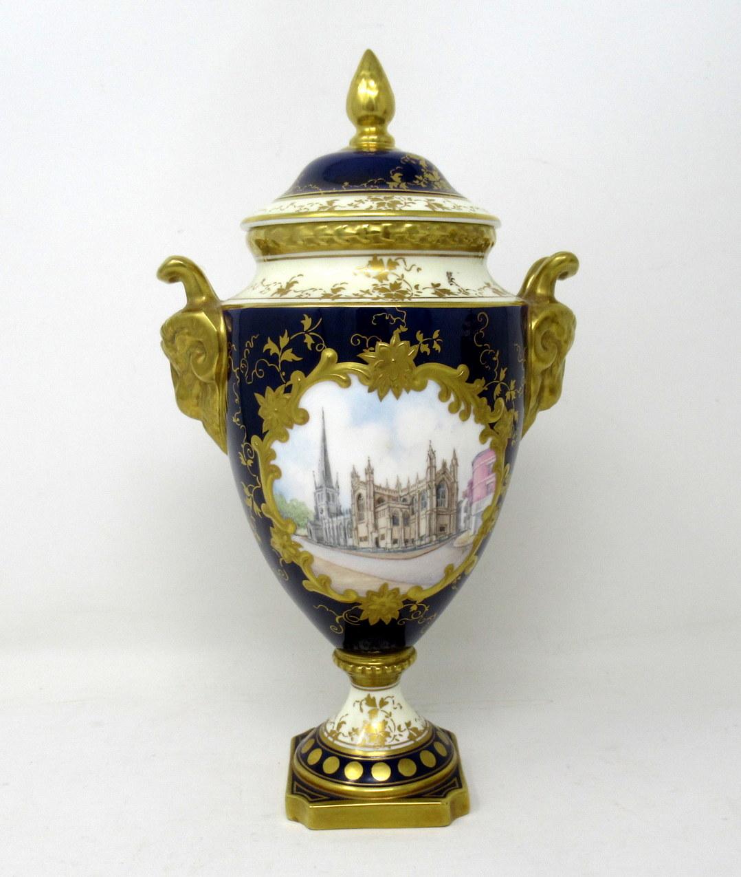 Fine pair of hand painted and signed English porcelain coalport limited edition lidded urns of traditional form with lavish gilded twin handles modelled as ram’s heads, complete with original finial covers, early 20th century.

One vase depicts a
