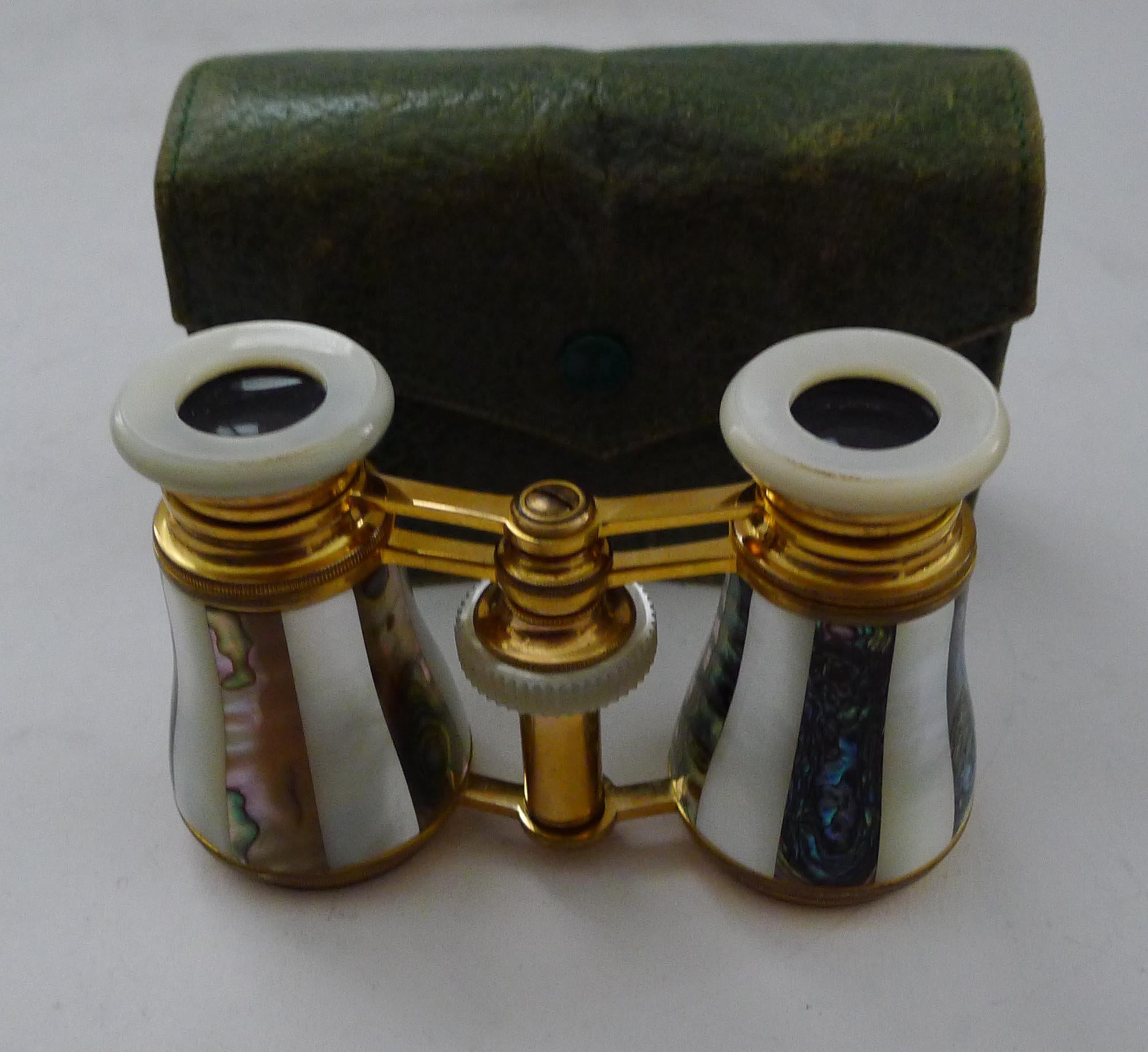 A stunning pair of French Opera glasses made from gilded brass, all intact and original.  The glasses are clad in alternating Mother of Pearl or Nacre shell and Abalone shell, creating a striped design.

The underside of the frame is struck 