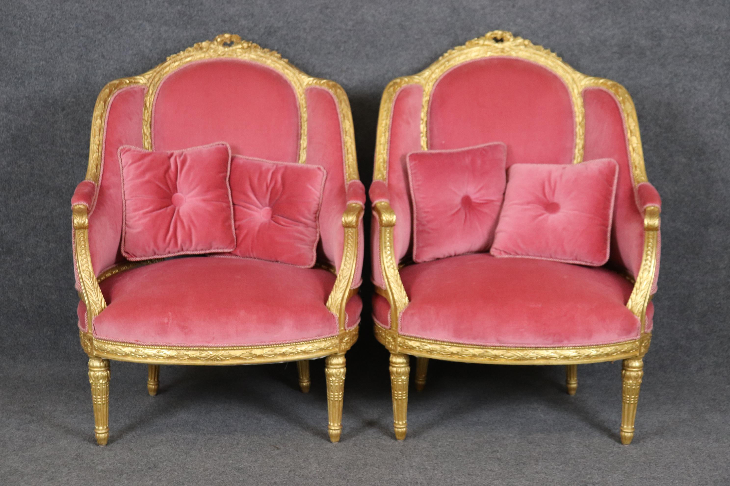 This is a gorgeous pair of rose velvet expertly carved French-made pair of bergere chairs. The chairs are some of the finest we have ever had. The gold is rich and luminous and in good condition. These chairs show only minor signs of wear and use.