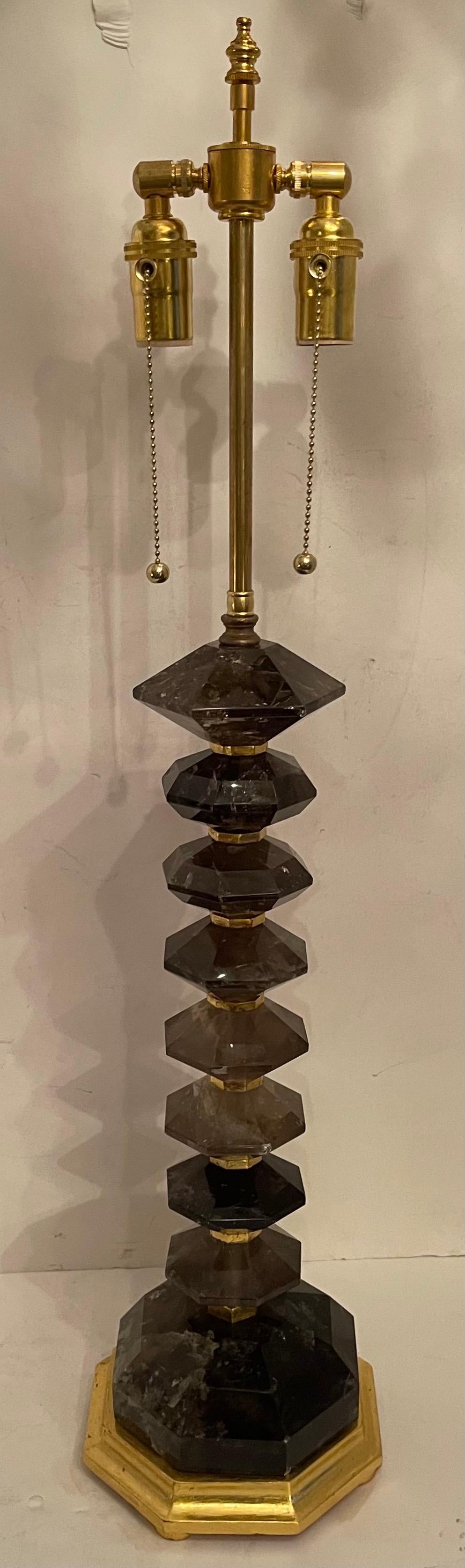 A wonderful pair of Modern, tea color, grey / brown rock crystal or smoke quartz with gold gilt wood base and spacers table lamps.
Completely rewired with new sockets.
Measures: H 33.5” x W 7”.