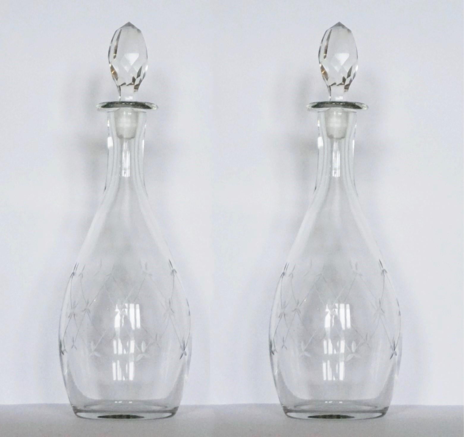 A fine pair of Victorian blown crystal tapered decanters or carafes finely hand-cut with elegant motivs, with its original hand-faceted rock crystal tall stoppers, England, circa 1860-1870. Both decanters in very good condition, no chips or cracks,