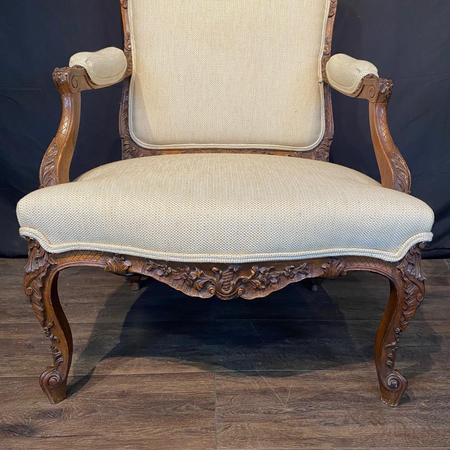 Ein feines Paar exquisit geschnitzter Fauteuils aus dem 19. Jahrhundert, die in Frankreich aus massivem Nussbaum handgefertigt wurden. Mit einer geformten Rückenlehne mit einem Kamm mit fein geschnitzten Blumen- und Blattmotiven und eleganten,