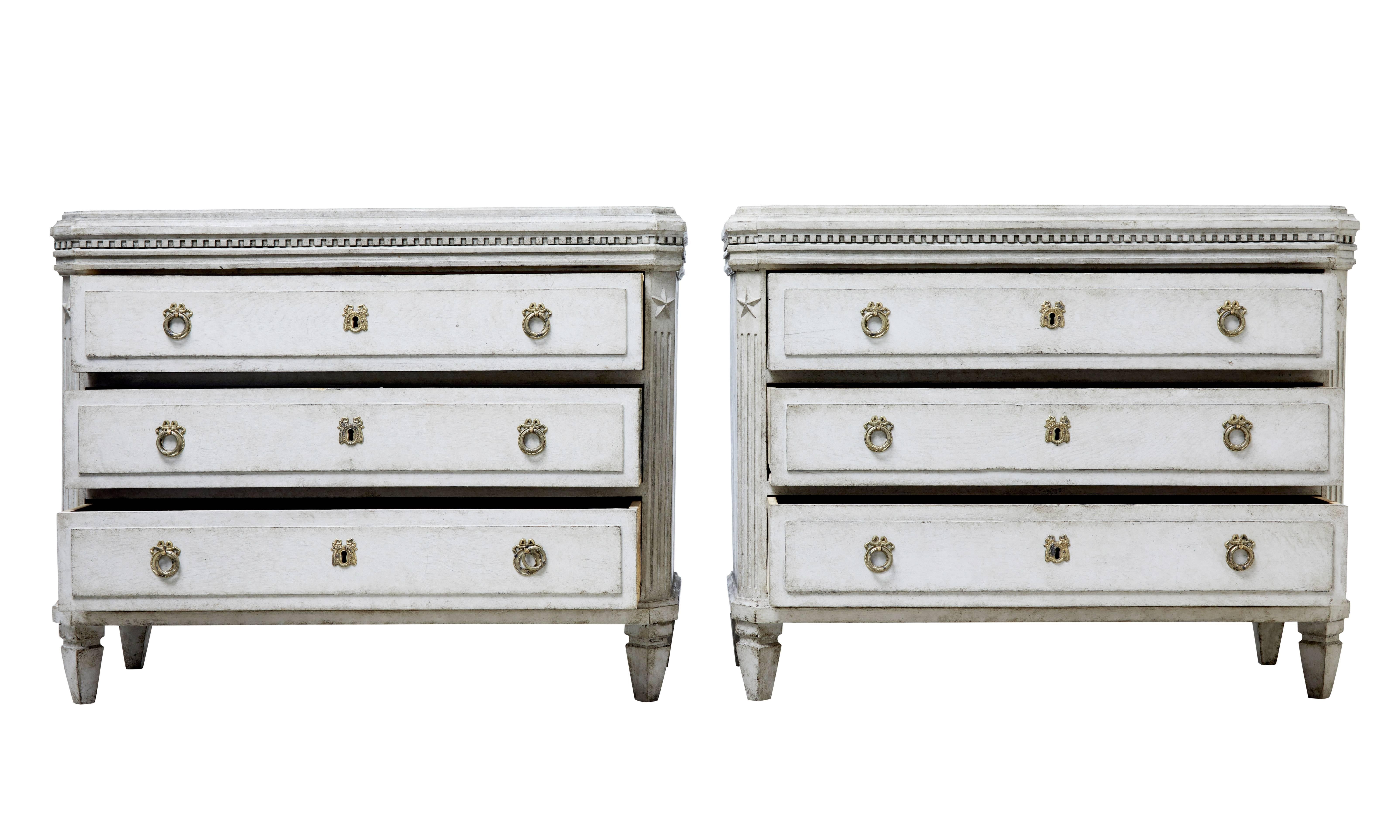 Good quality pair of Swedish commodes in the Gustavian taste, circa 1860.

Three drawers fitted with ornate brass hardware. Dentil detail below the shaped top. Canted corners with fluted elements and applied star motif.

Standing on short