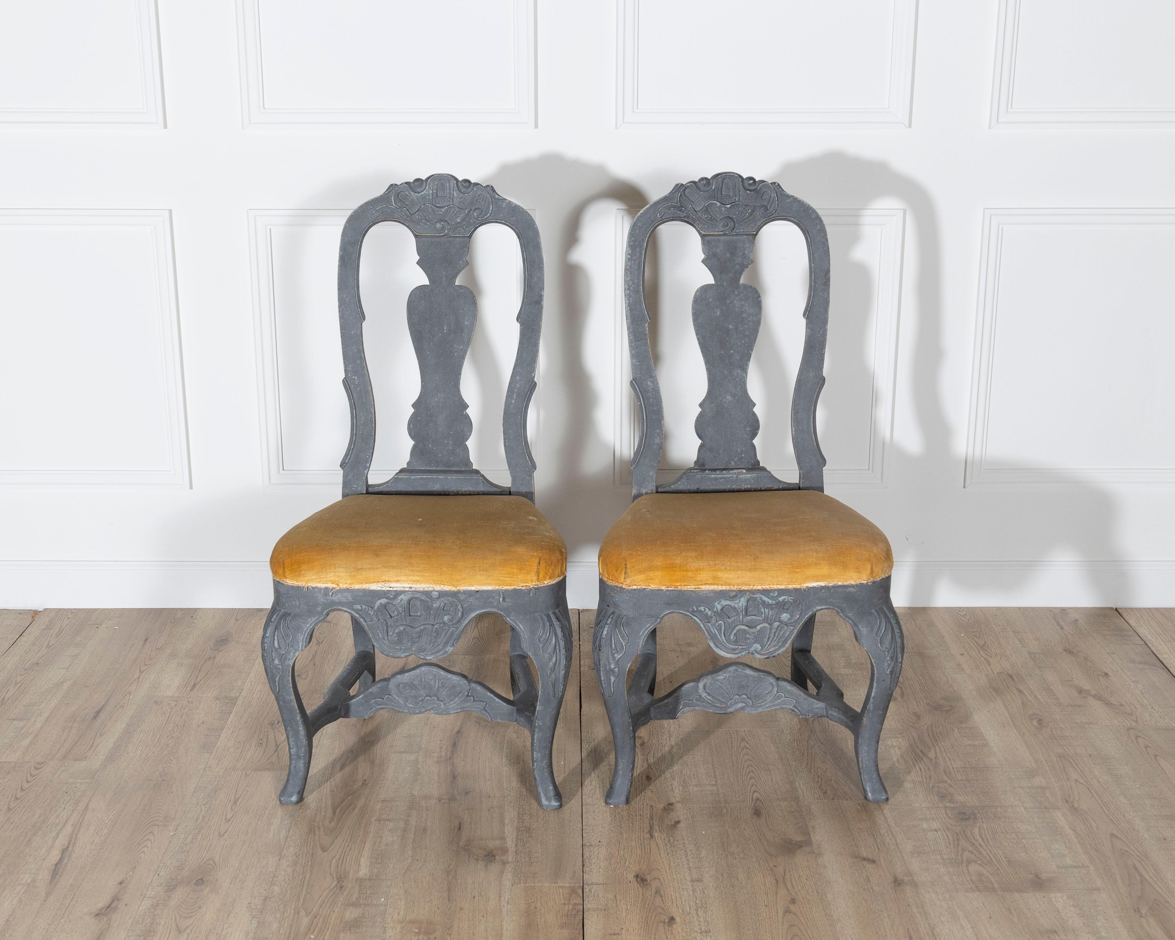 Cette paire de chaises rococo suédoises du XIXe siècle allie l'élégance sculpturale à une palette audacieuse et sombre. Peintes dans un riche noir mat, les chaises présentent un dossier ballon aux contours gracieux, sculpté de motifs floraux et