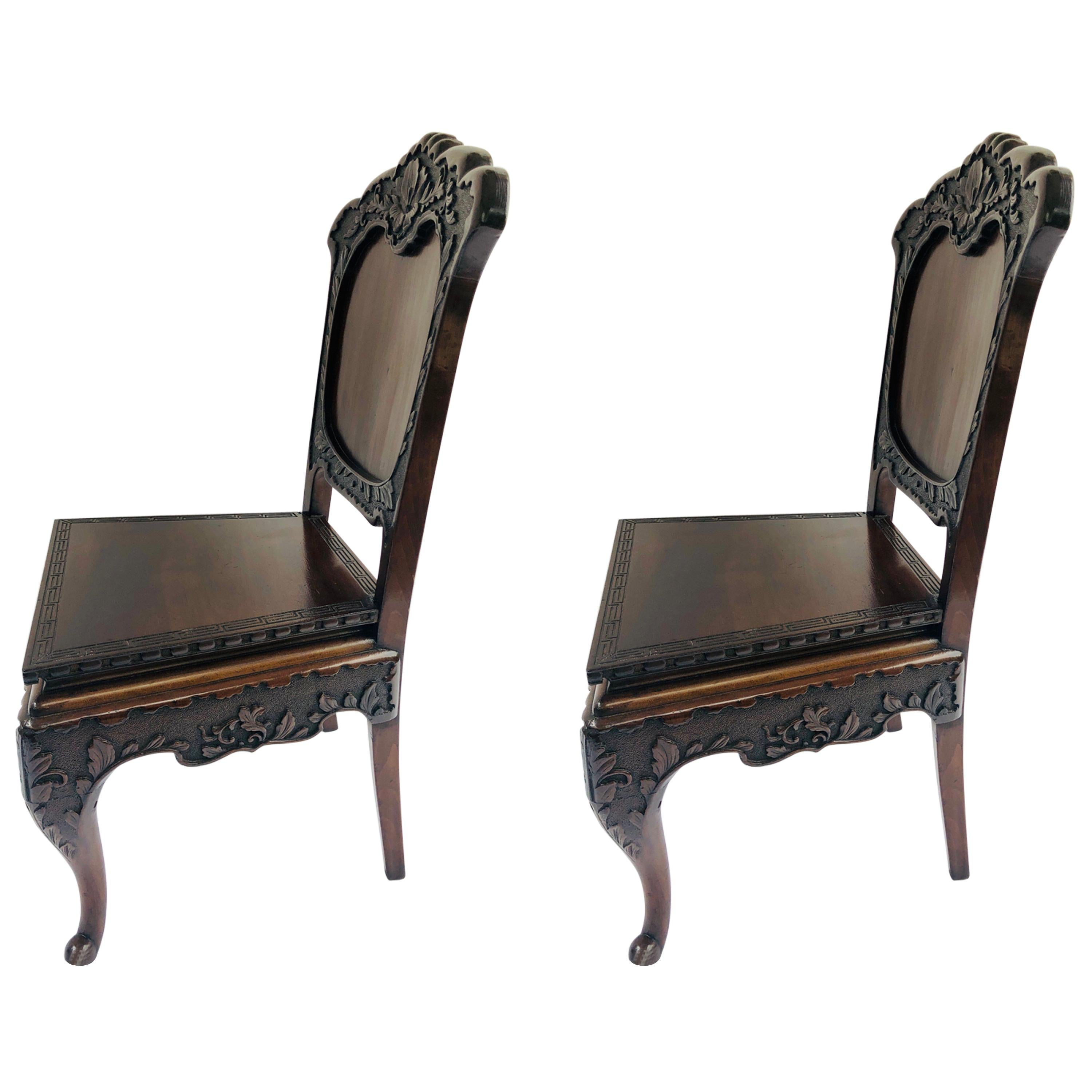 Fine pair of antique carved Chinese hall chairs having fine carved paneled fronts depicting a flower and leaf design. The carved front rail depicts the same leaf design. The carved shaped back boasts two bow inlays in the centre panel. They are